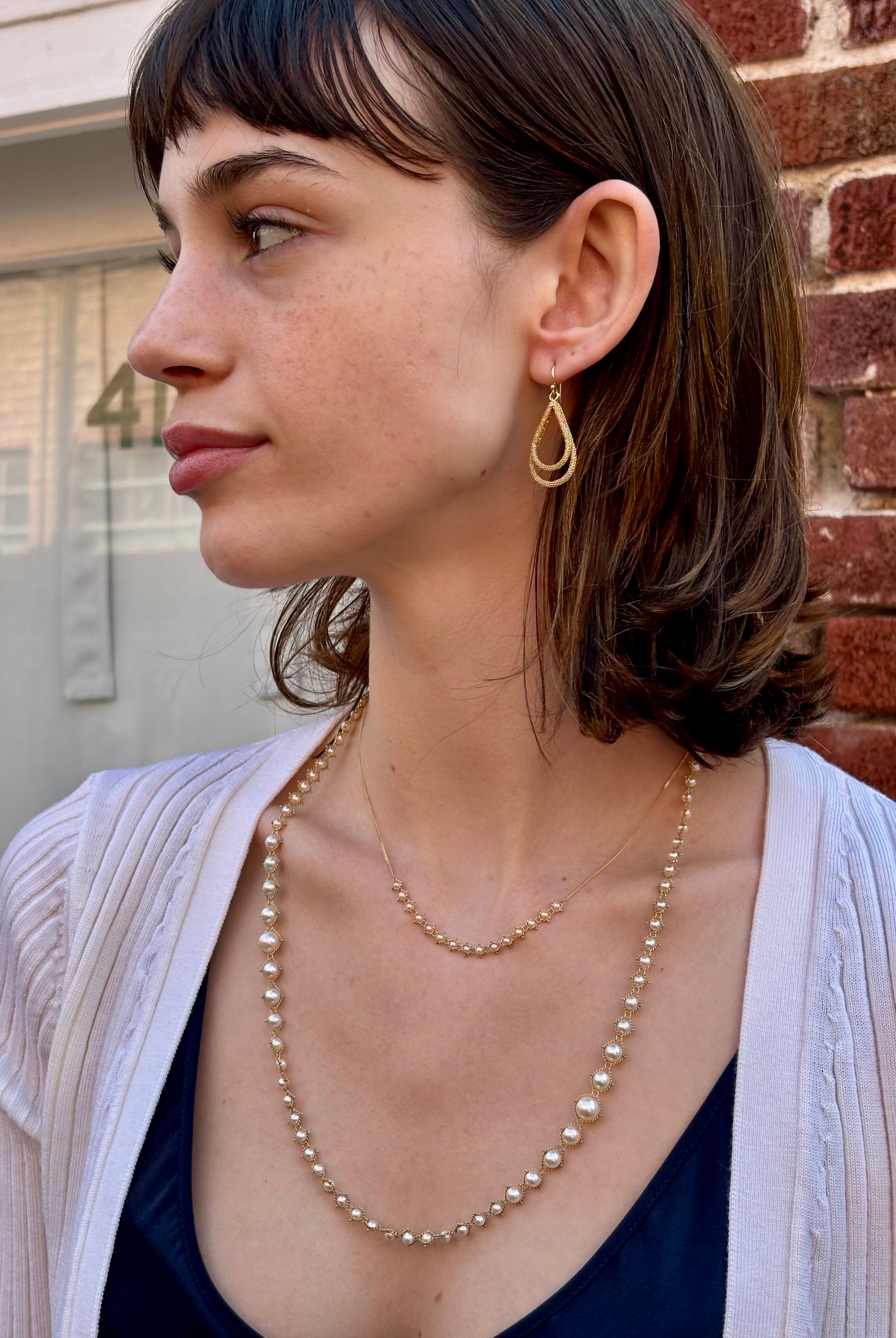 Woman wearing luxury designer Amali double Teardrop Stardust 18k yellow gold Earrings handmade in USA fine jewelry