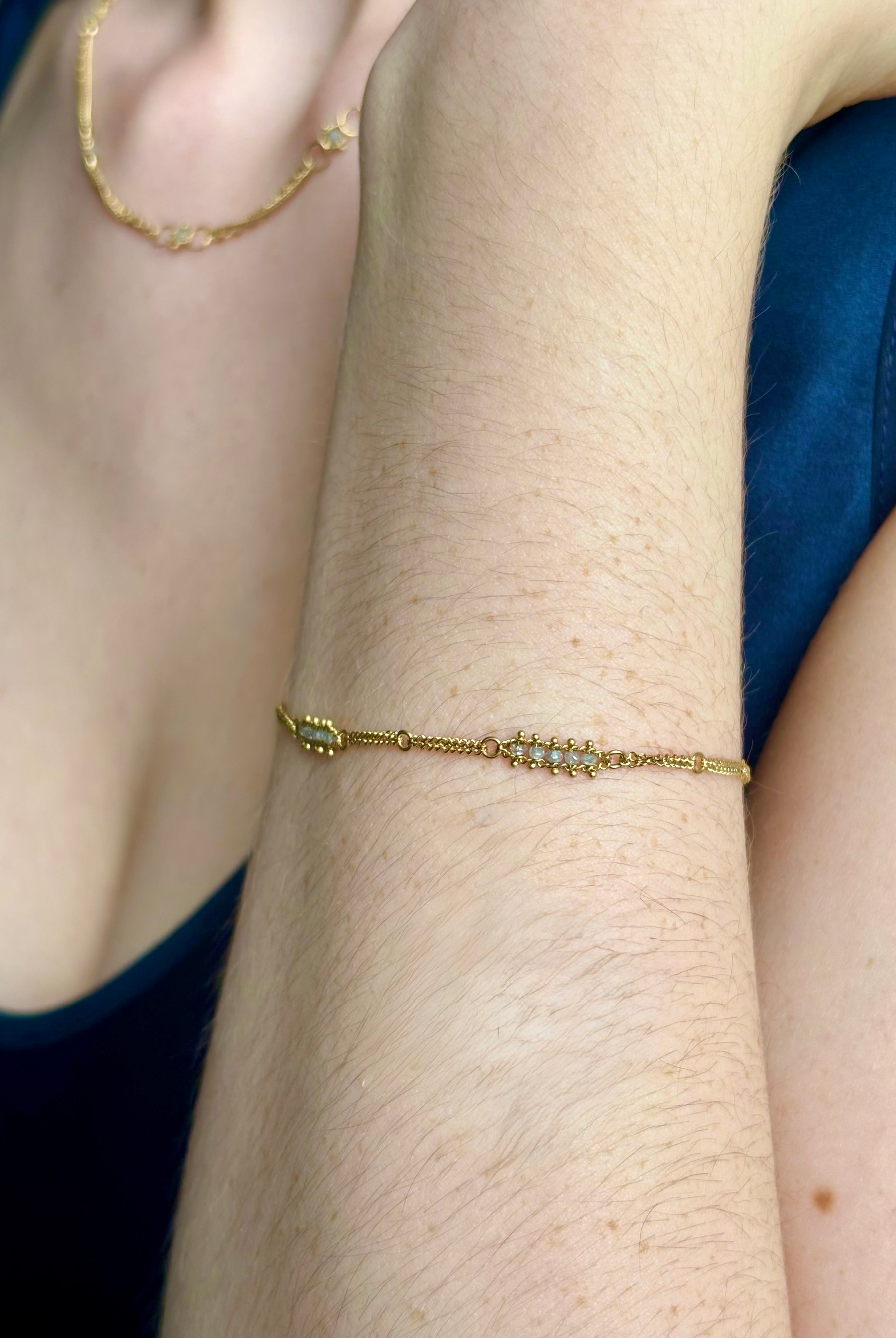 Woman wearing silver diamond and yellow gold bracelet with 5 diamond groupings all the way around by US fine jewelry designer Amali. A stylish modern take on a classic