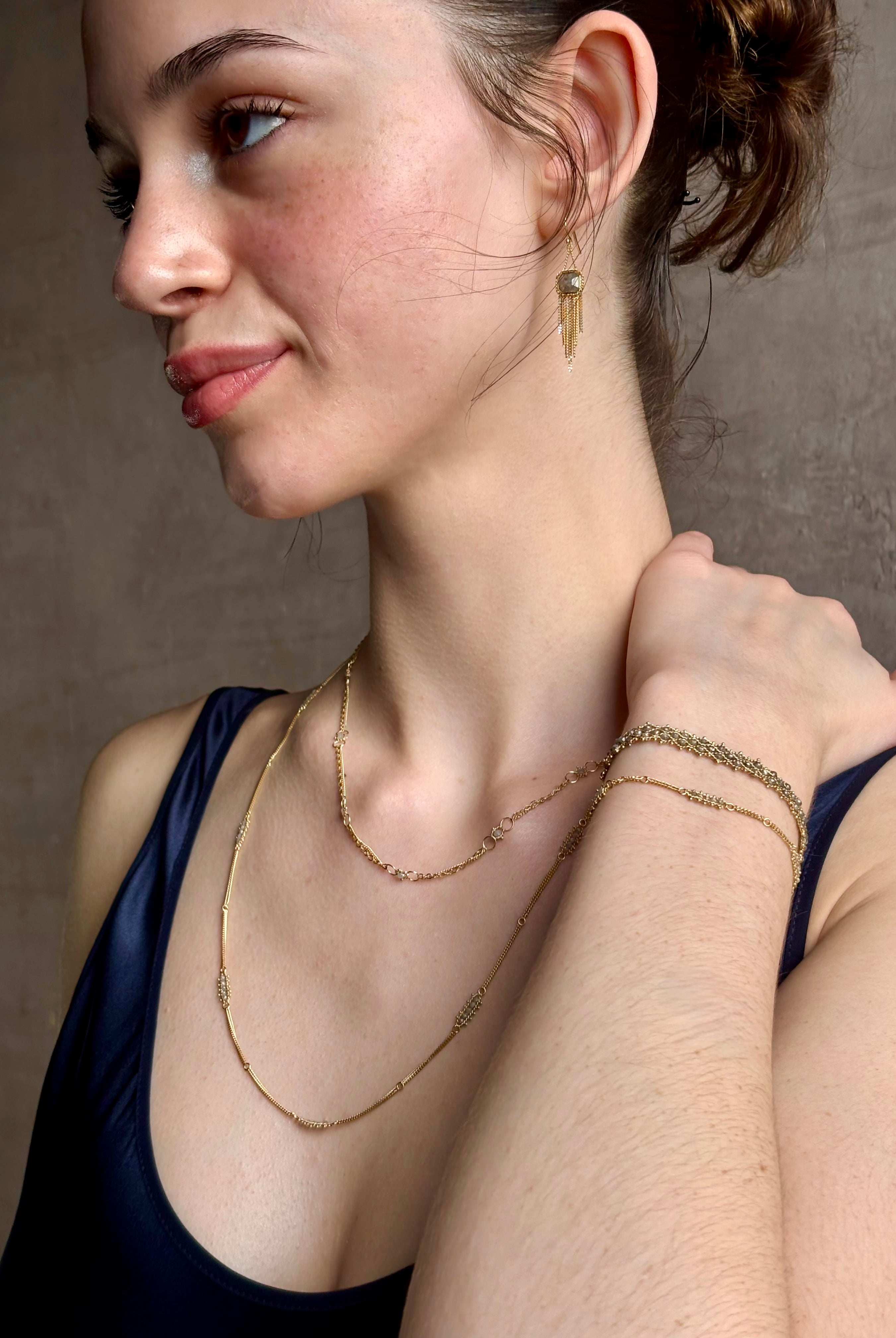 Woman wearing silver diamond and yellow gold bracelet with 5 diamond groupings all the way around by US fine jewelry designer Amali. A stylish modern take on a classic