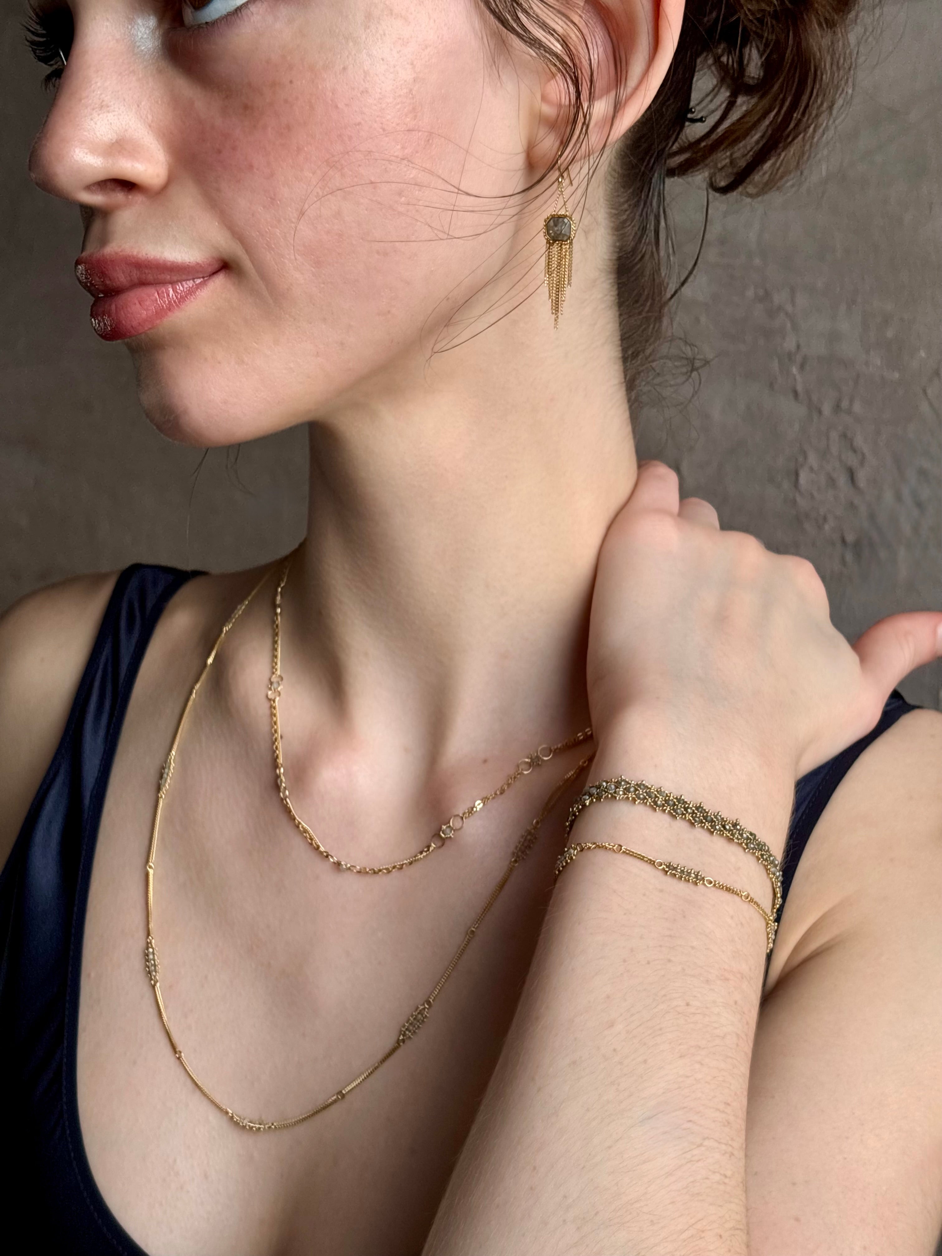 Woman wearing Amali Tassel silver diamond drop Earrings in 18k yellow gold in an inspiring 21st century modern design