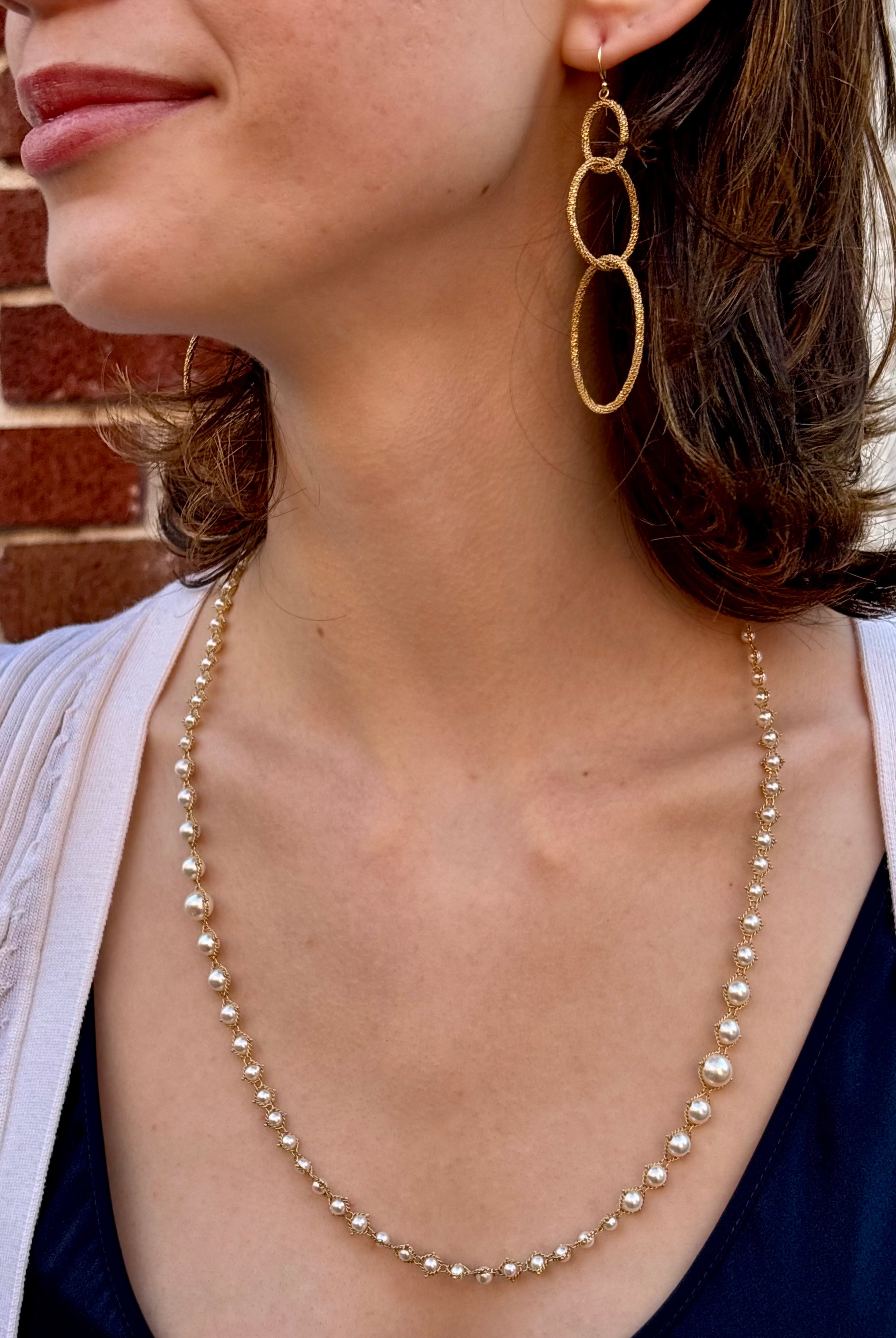 Image of a woman wearing fine jewelry Amali Triple Oval Stardust 18k yellow gold designer Earrings handmade in USA