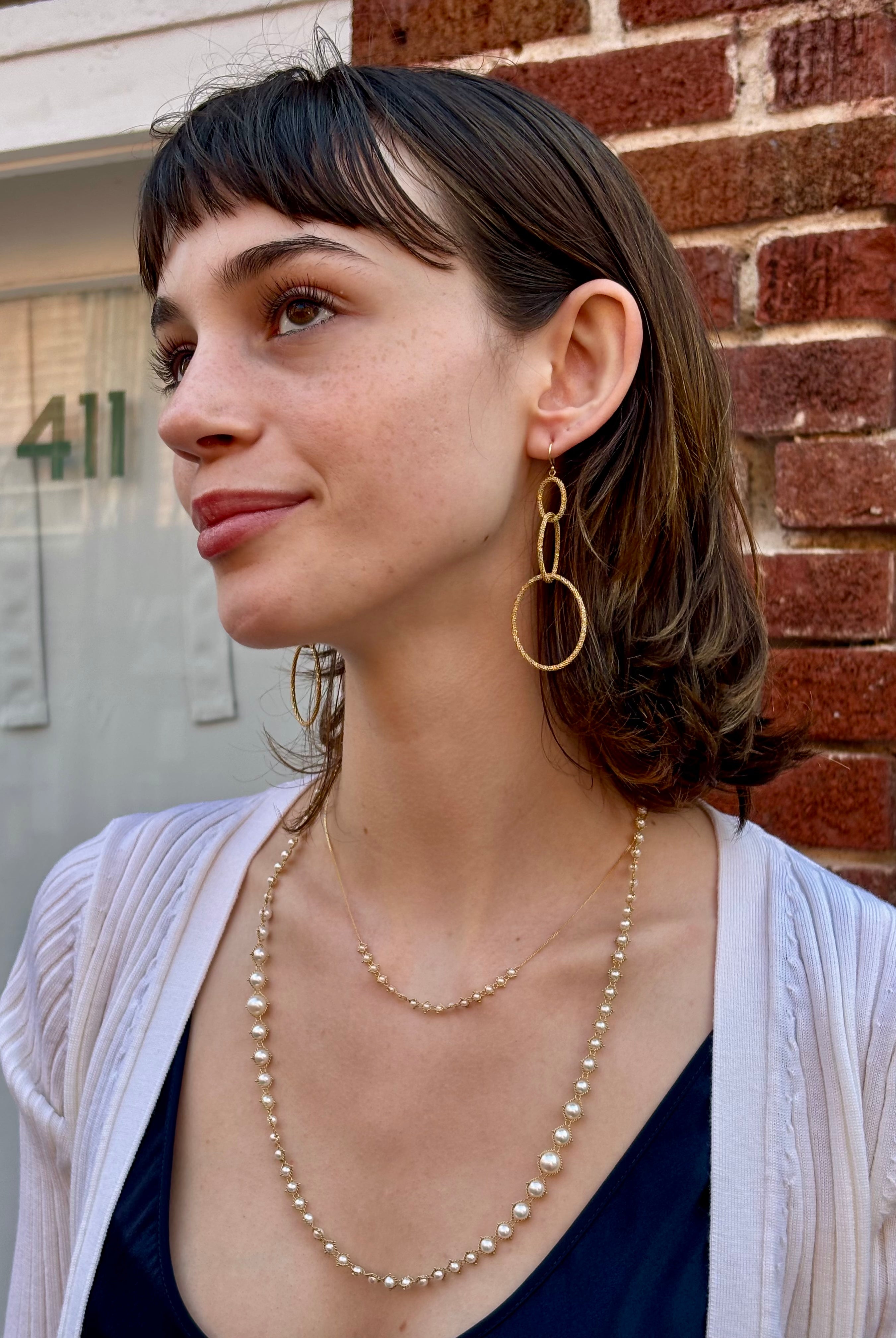 Woman wearing fine jewelry Amali Triple Oval Stardust 18k yellow gold designer Earrings handmade in USA