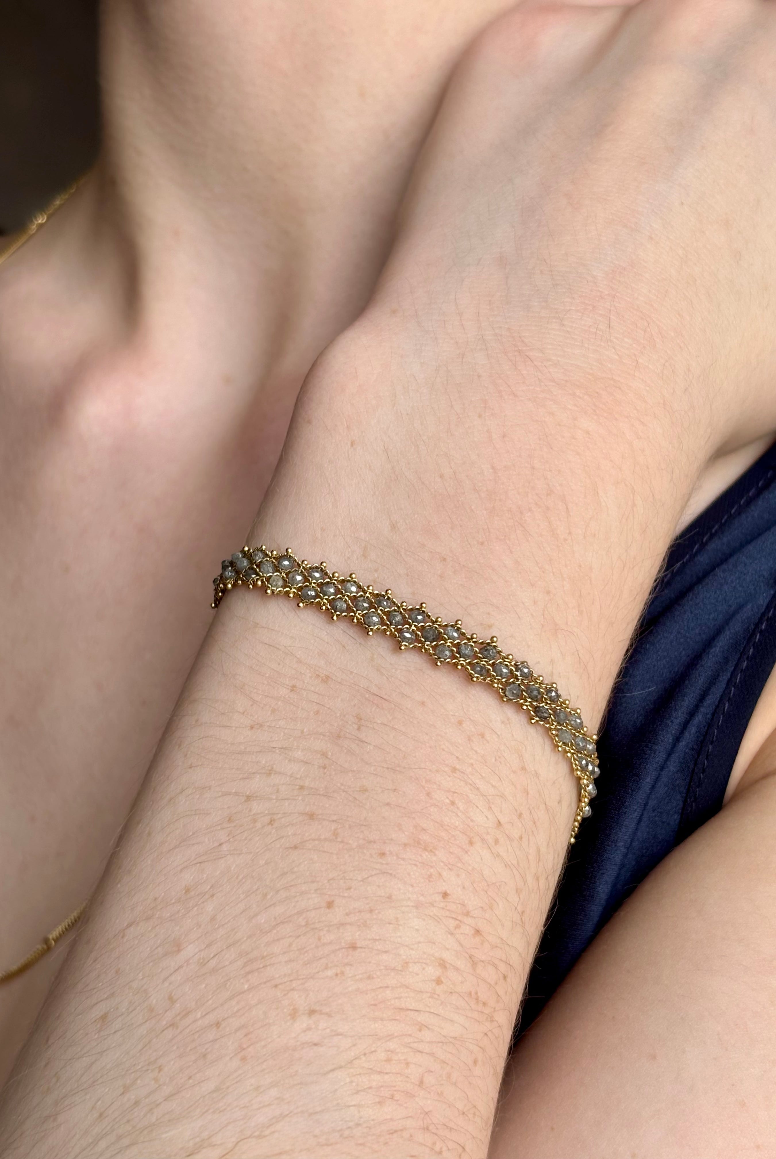 Woman wearing premium New York fine jewelry designer Amali Woven Bracelet in Grey Diamonds and 18K Gold in a sleek modern design