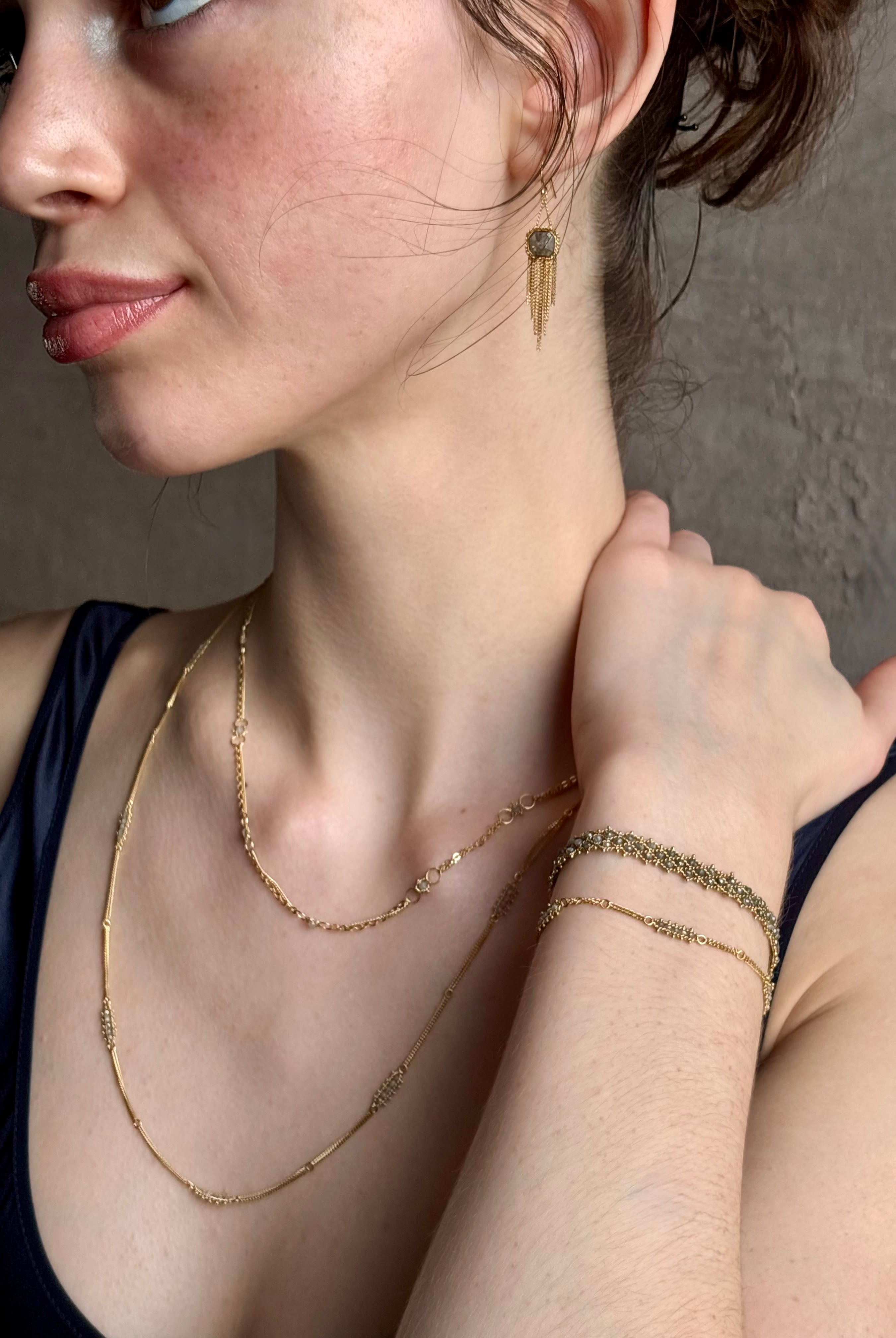 Woman wearing premium New York fine jewelry designer Amali Woven Bracelet in Grey Diamonds and 18K Gold in a sleek modern design