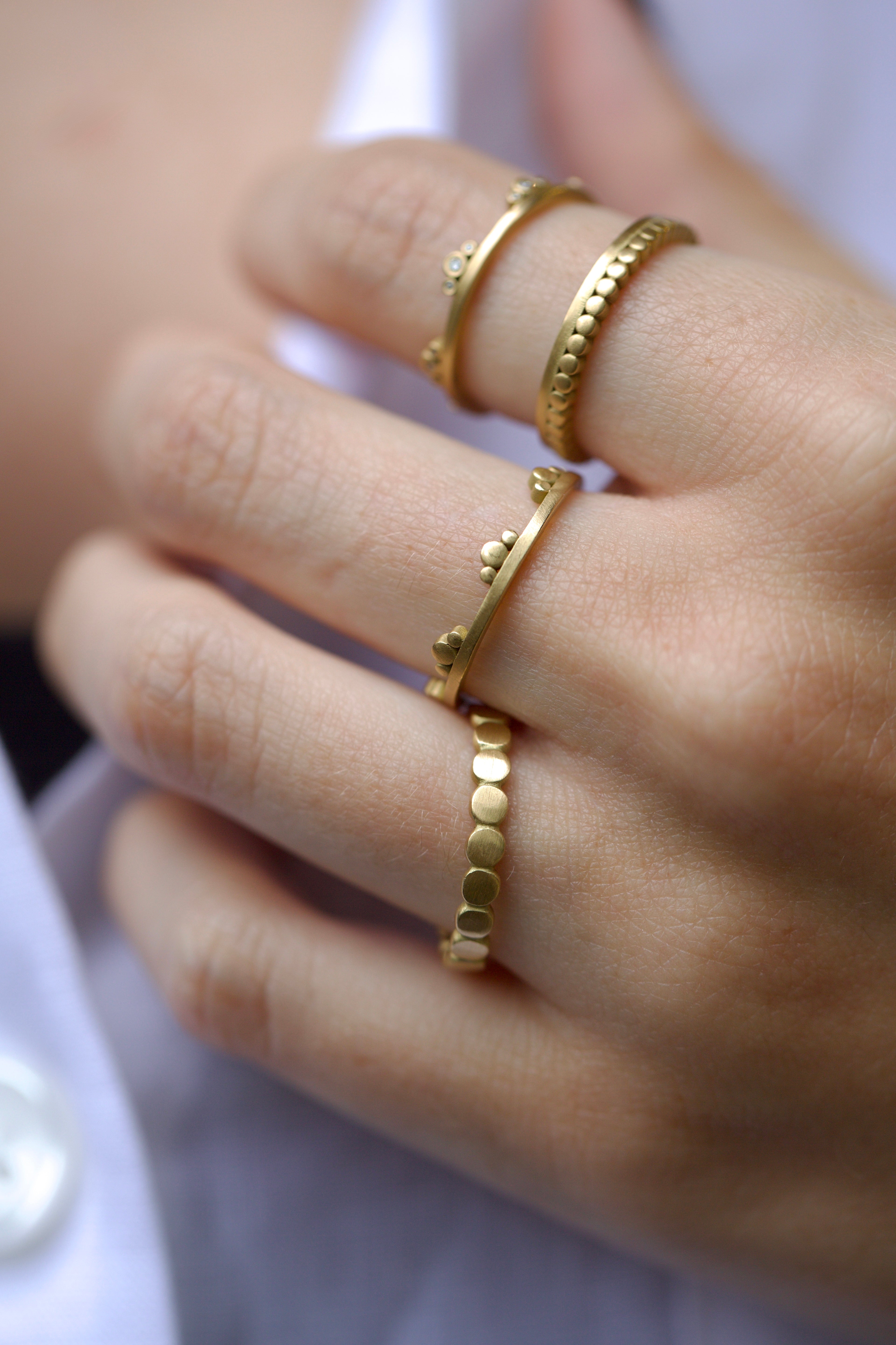 Image of American Jeweler Ananda Khalsa Diamond Side Trio 18k gold matte finish ring with seven 1mm white diamond trio encircling arrangement
