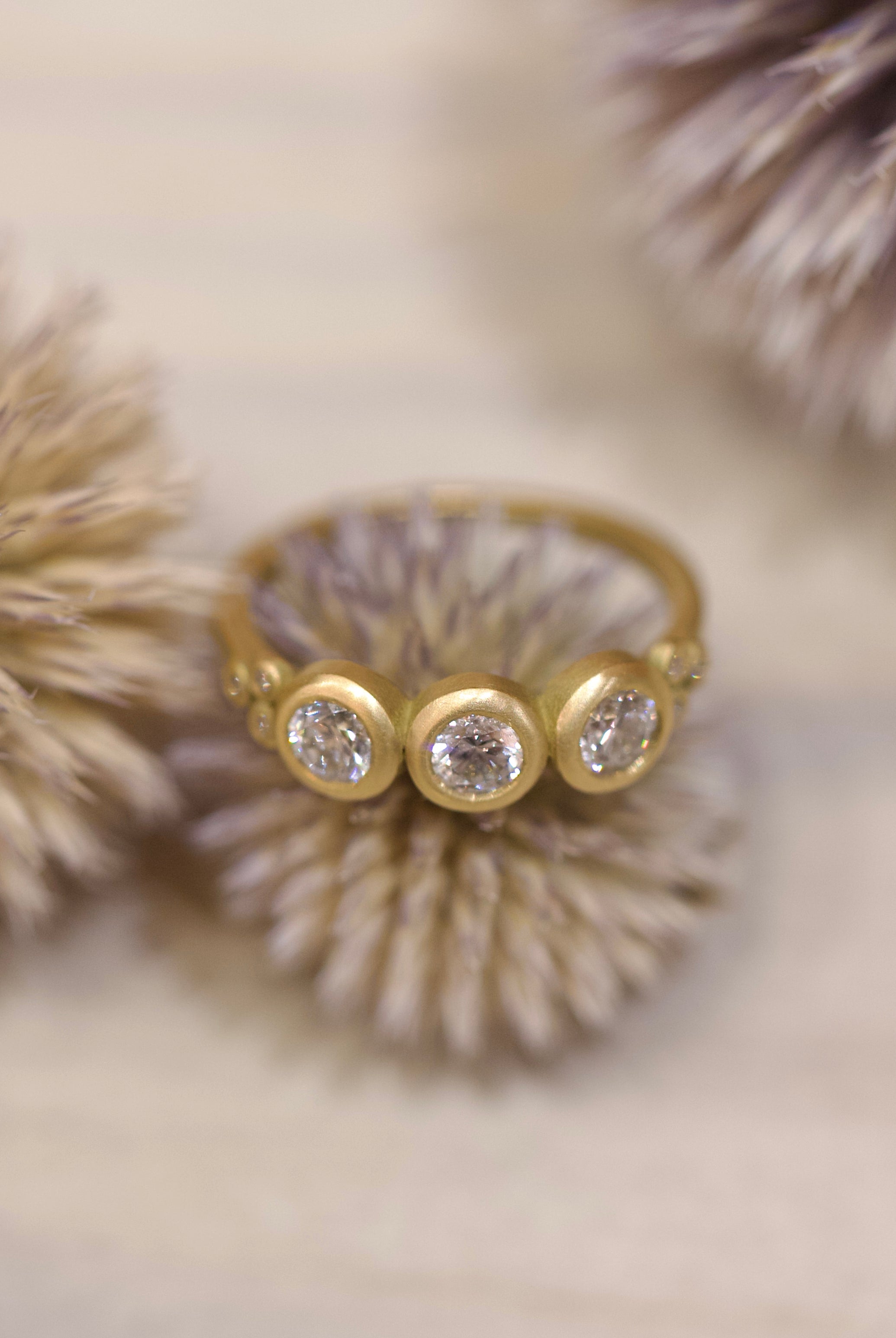 Image of Ananda Khalsa luxury handmade 18k hammered matte gold ring with three 4mm brilliant cut white diamonds delivering timeless elegance