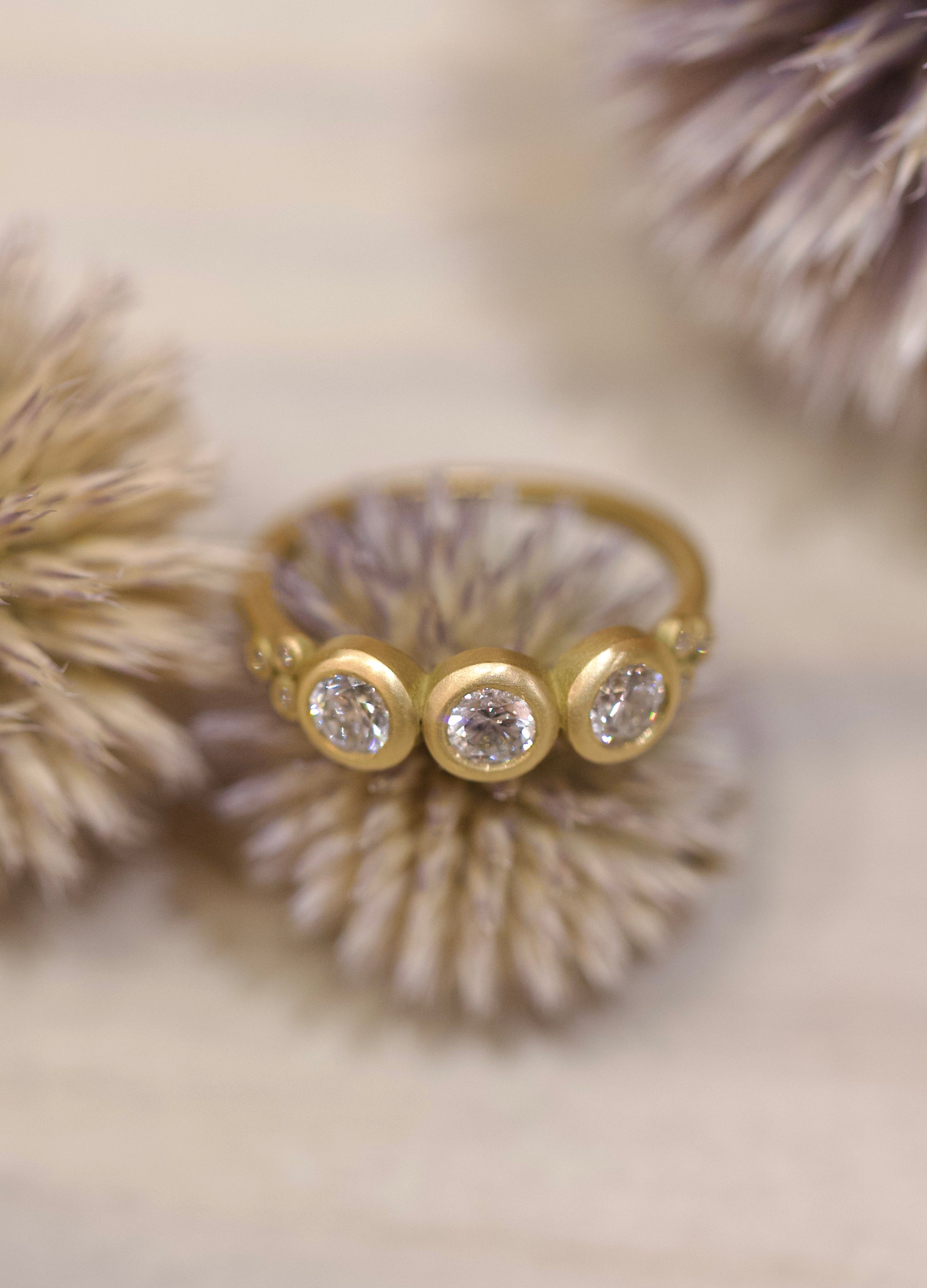 Image of Ananda Khalsa luxury handmade 18k hammered matte gold ring with three 4mm brilliant cut white diamonds delivering timeless elegance
