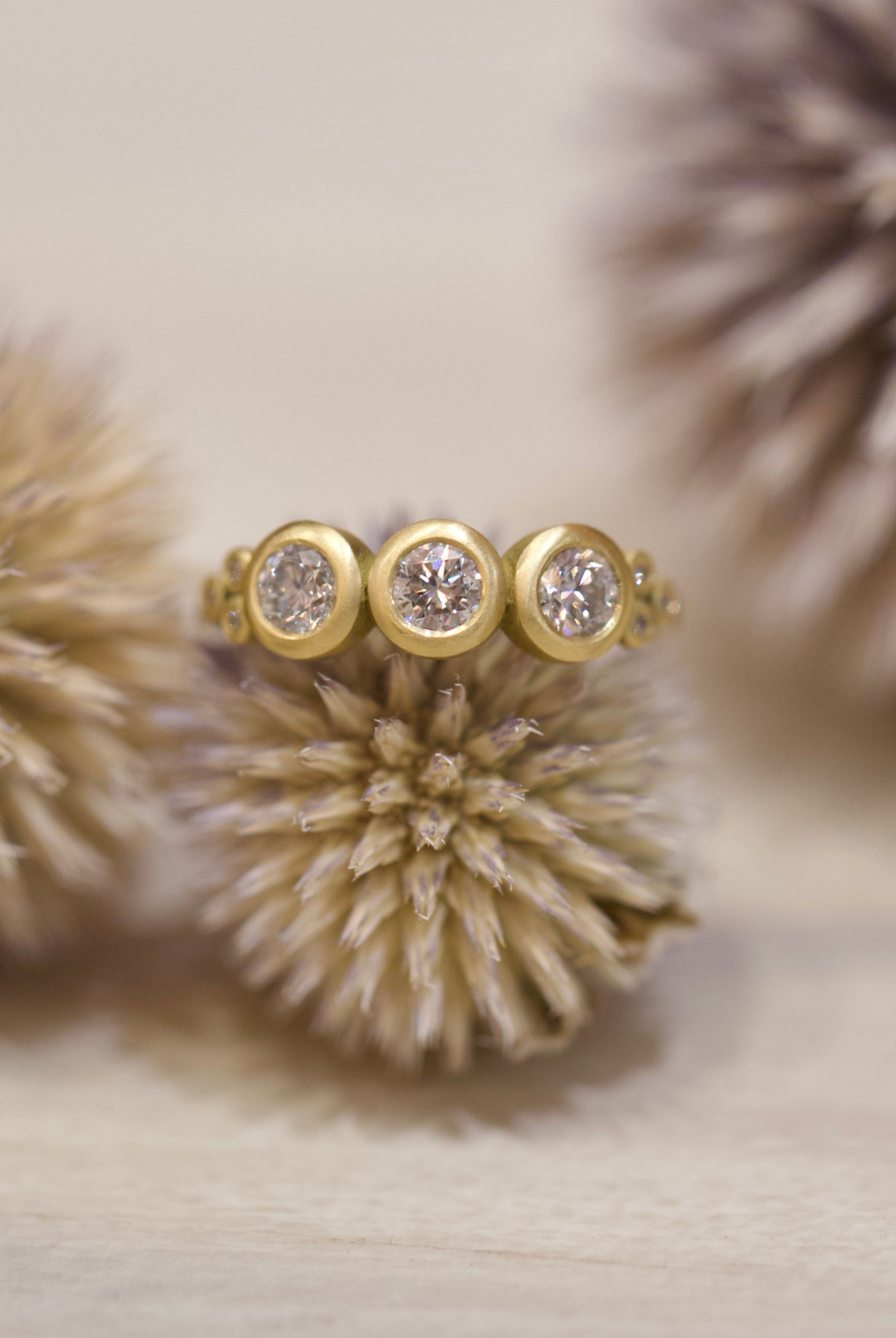 Image of Ananda Khalsa luxury handmade 18k hammered matte gold ring with three 4mm brilliant cut white diamonds delivering timeless elegance
