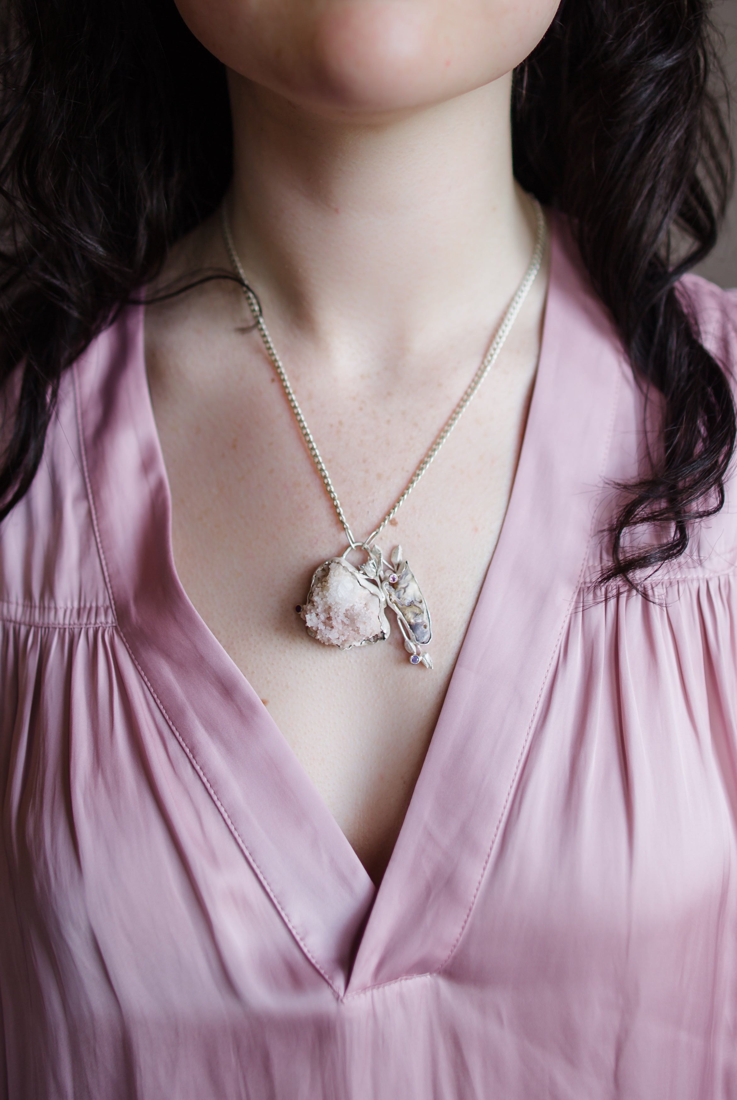 Image featuring a woman wearing North Carolina artist Anna Johnson skull Necklace with Rat skull, zeolite, opalescent rubies, depletion gilded silver and cast garlic chive flowers
