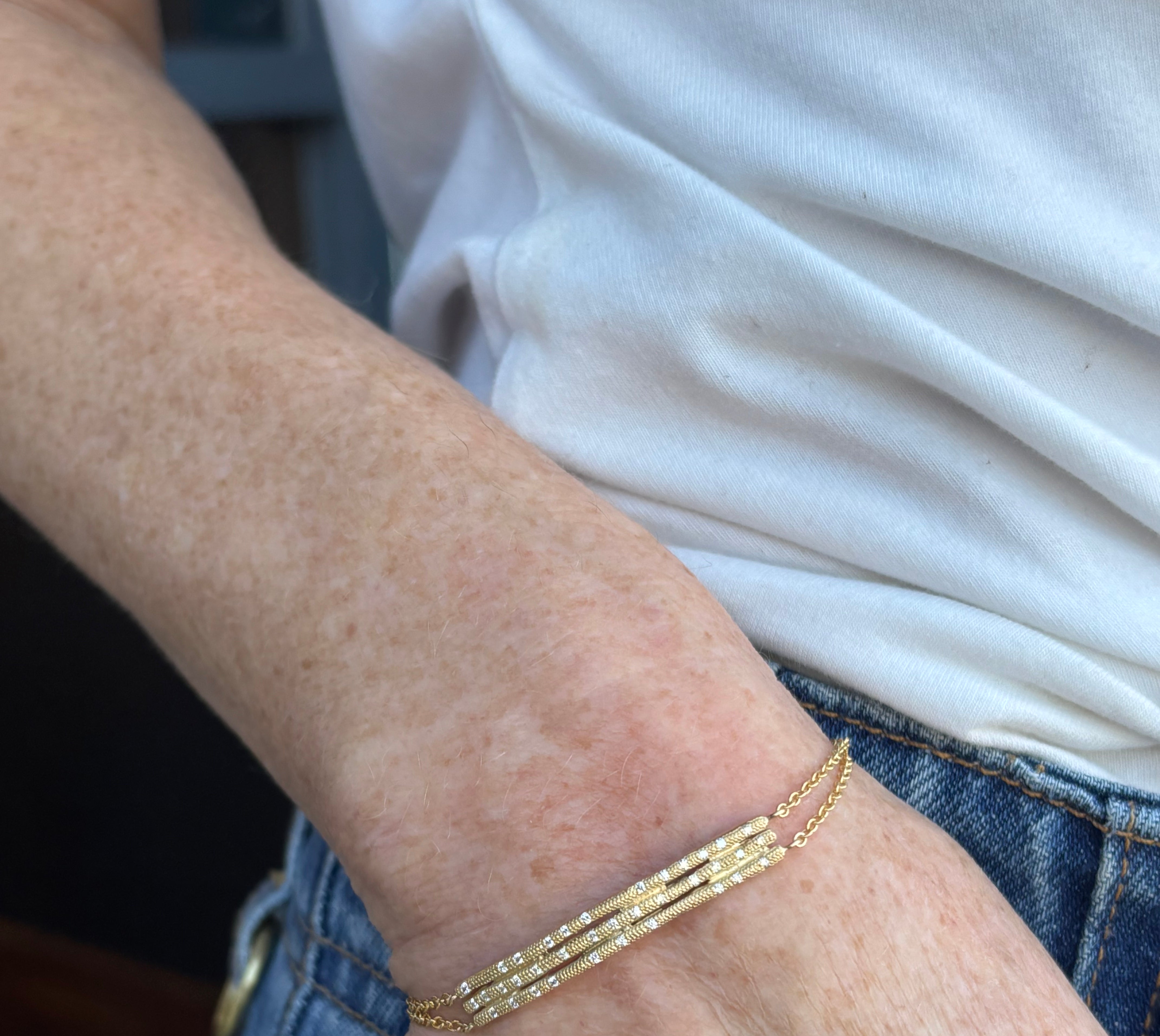 Image of woman wearing fine jewelry designer ANNE SPORTUN Stardust Triple Stick Bracelet in 18K Yellow Gold and Diamonds with an adjustable clasp