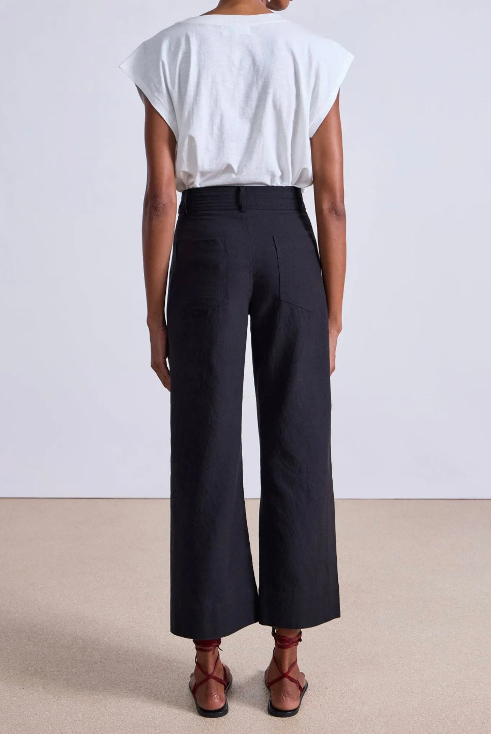 Model wearing expertly tailored Apiece Apart Merida high rise black pants with belt loops and back pockets