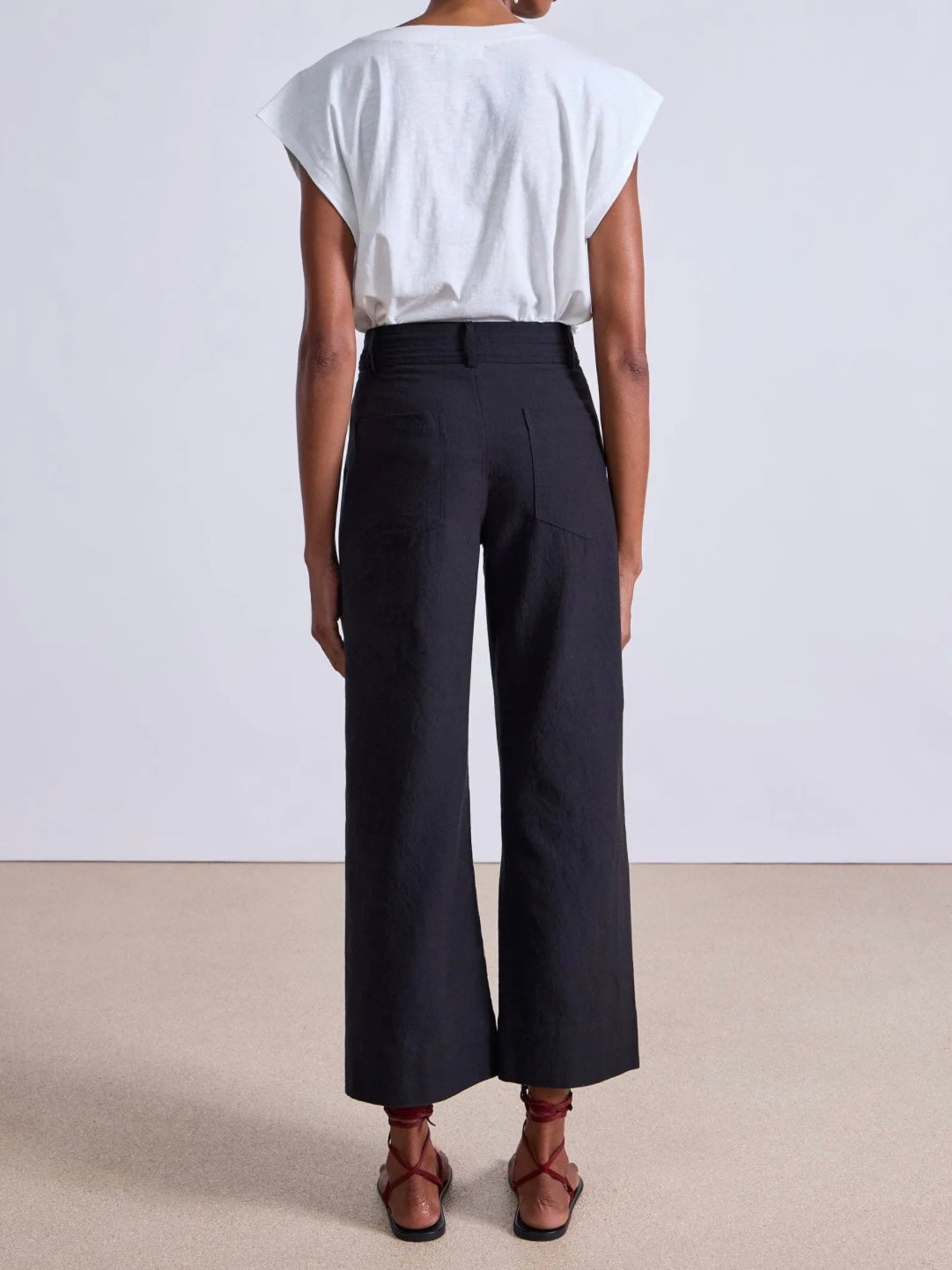 Model wearing expertly tailored Apiece Apart Merida high rise black pants with belt loops and back pockets