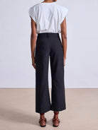 Model wearing expertly tailored Apiece Apart Merida high rise black pants with belt loops and back pockets