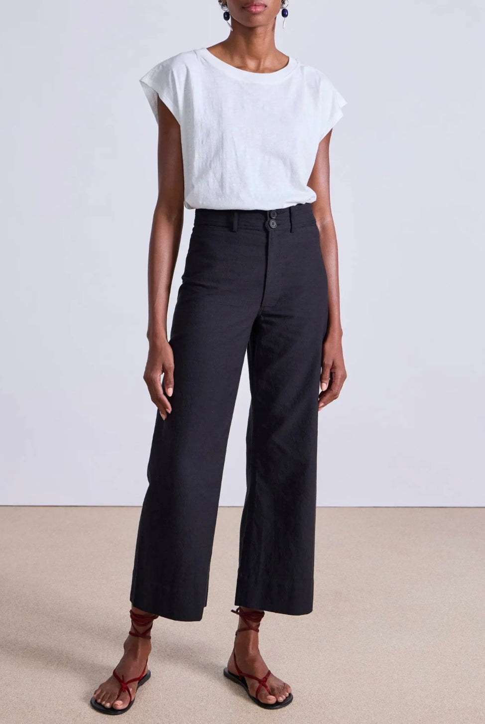 Model wearing expertly tailored Apiece Apart Merida high rise black pants with belt loops and front zip