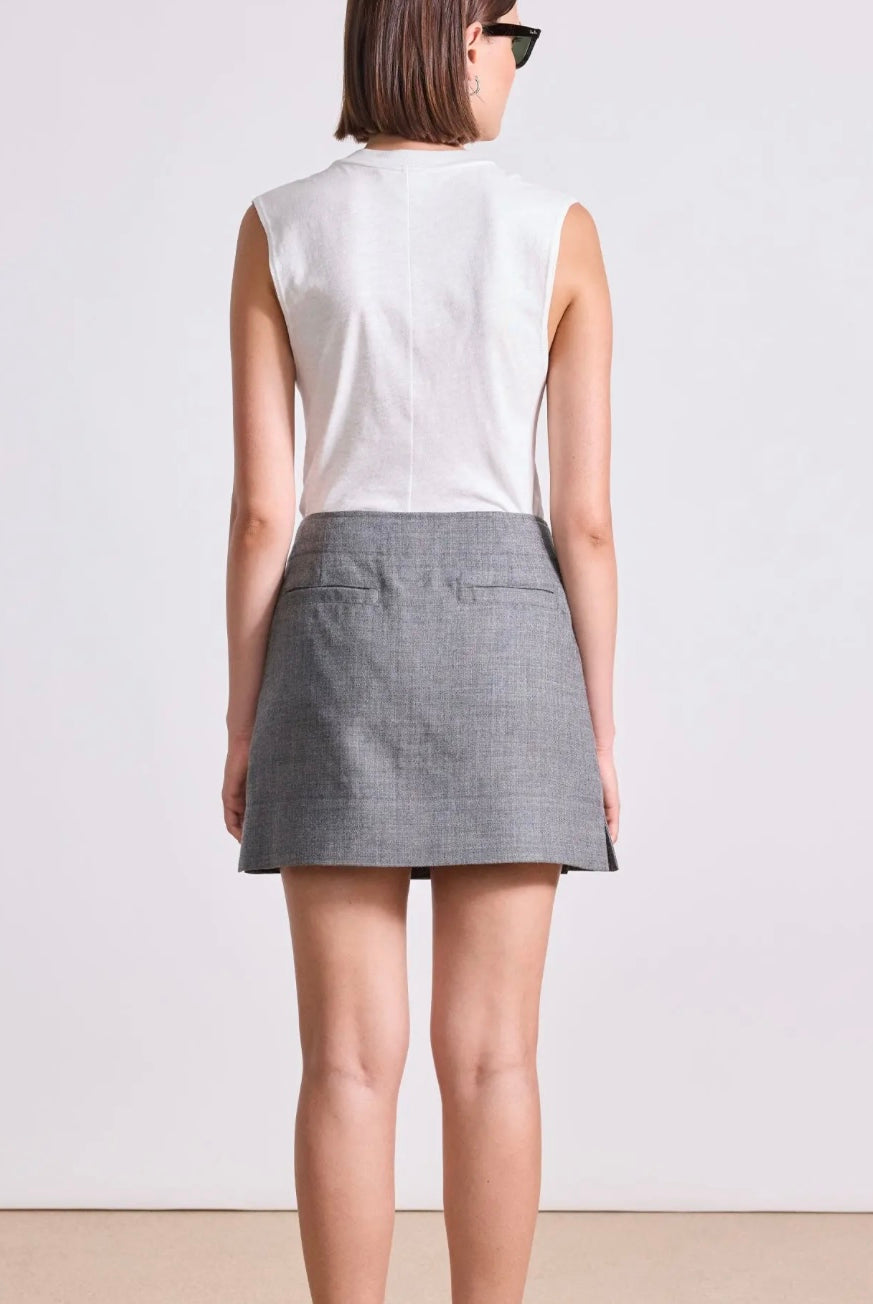 Model wearing Apiece Apart Marta mini skirt in sophisticated neutral heathered grey with back trouser pocket detail