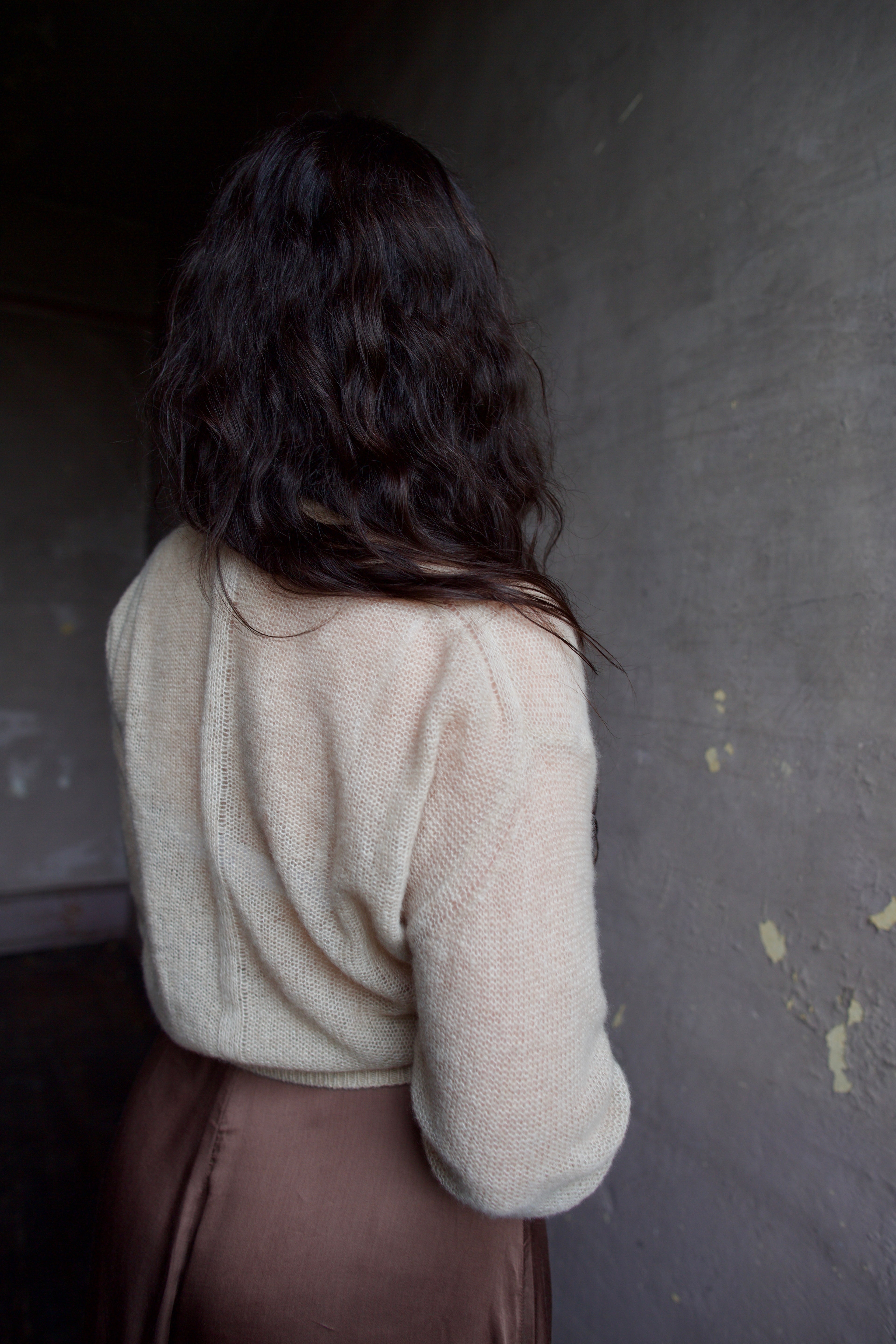 Model wearing Apiece Apart cashmere silk beige tissue weight sweater and brown skirt