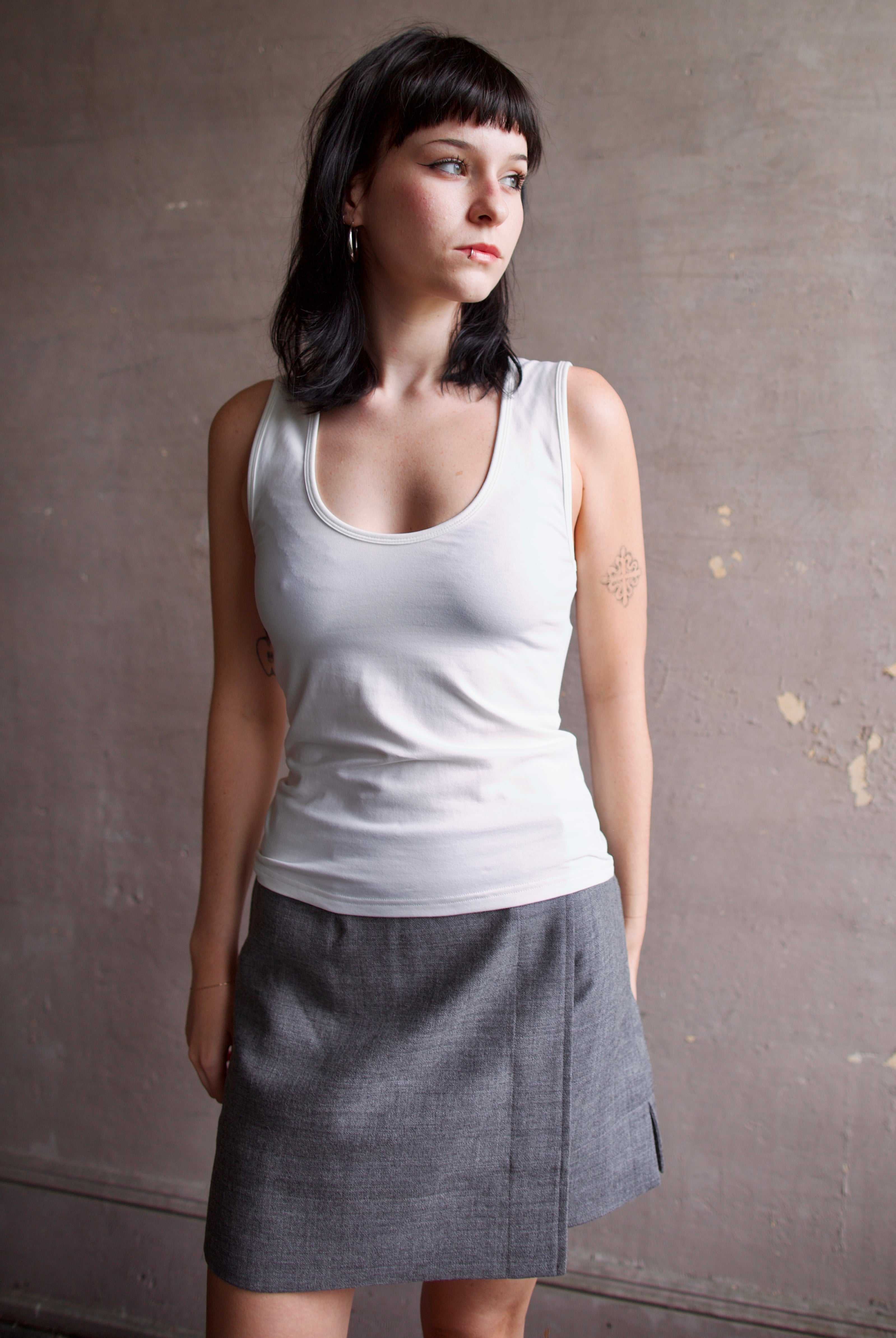 Model wearing a white cotton tank top with scoop neck and bra friendly shoulder straps from Apiece Apart