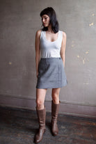 Model wearing Apiece Apart Marta mini skirt in sophisticated neutral heathered grey in virgin wool