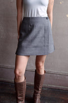 Model wearing Apiece Apart Marta mini skirt in sophisticated neutral heathered grey virgin wool