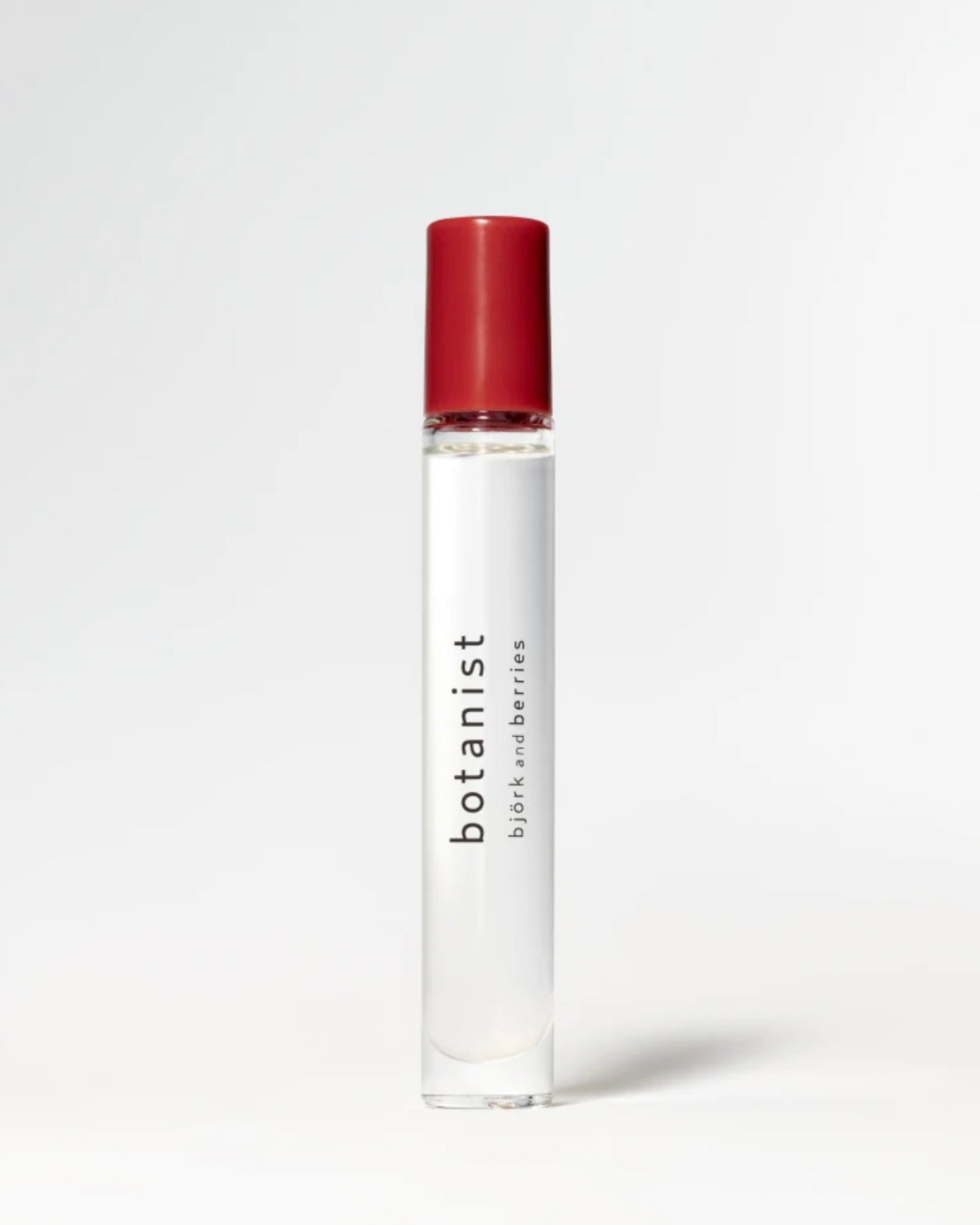 Image of BJORK AND BERRIES Botanist luxury personal fragrance perfume oil with notes of green apple, vetiver and patchouli in a Scandinavian minimalist design clear glass bottle and red lid