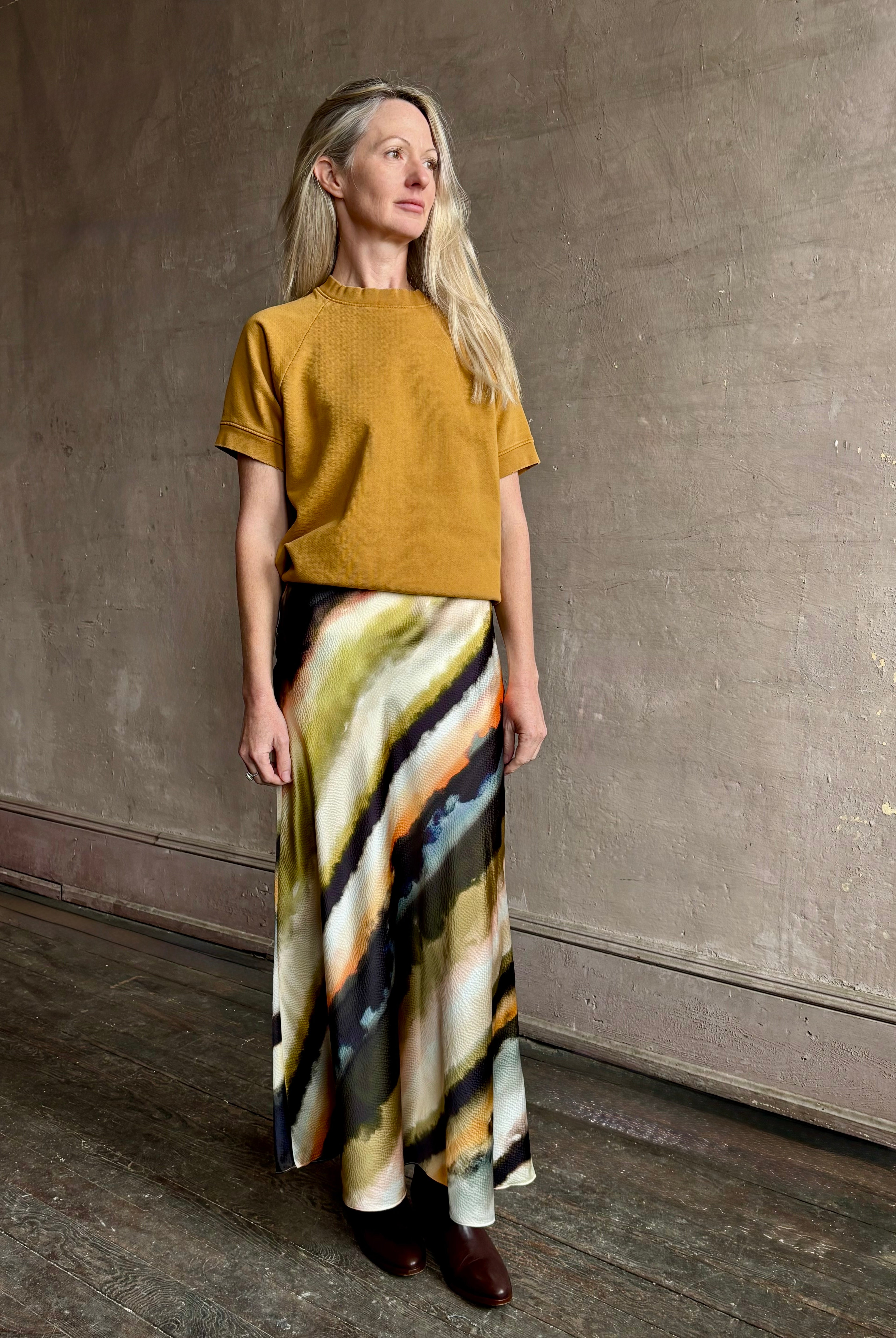 Image of mature woman wearing designer Cara Cara hammered silk maxi slip skirt with abstract multi-color print that can be dressed up or down