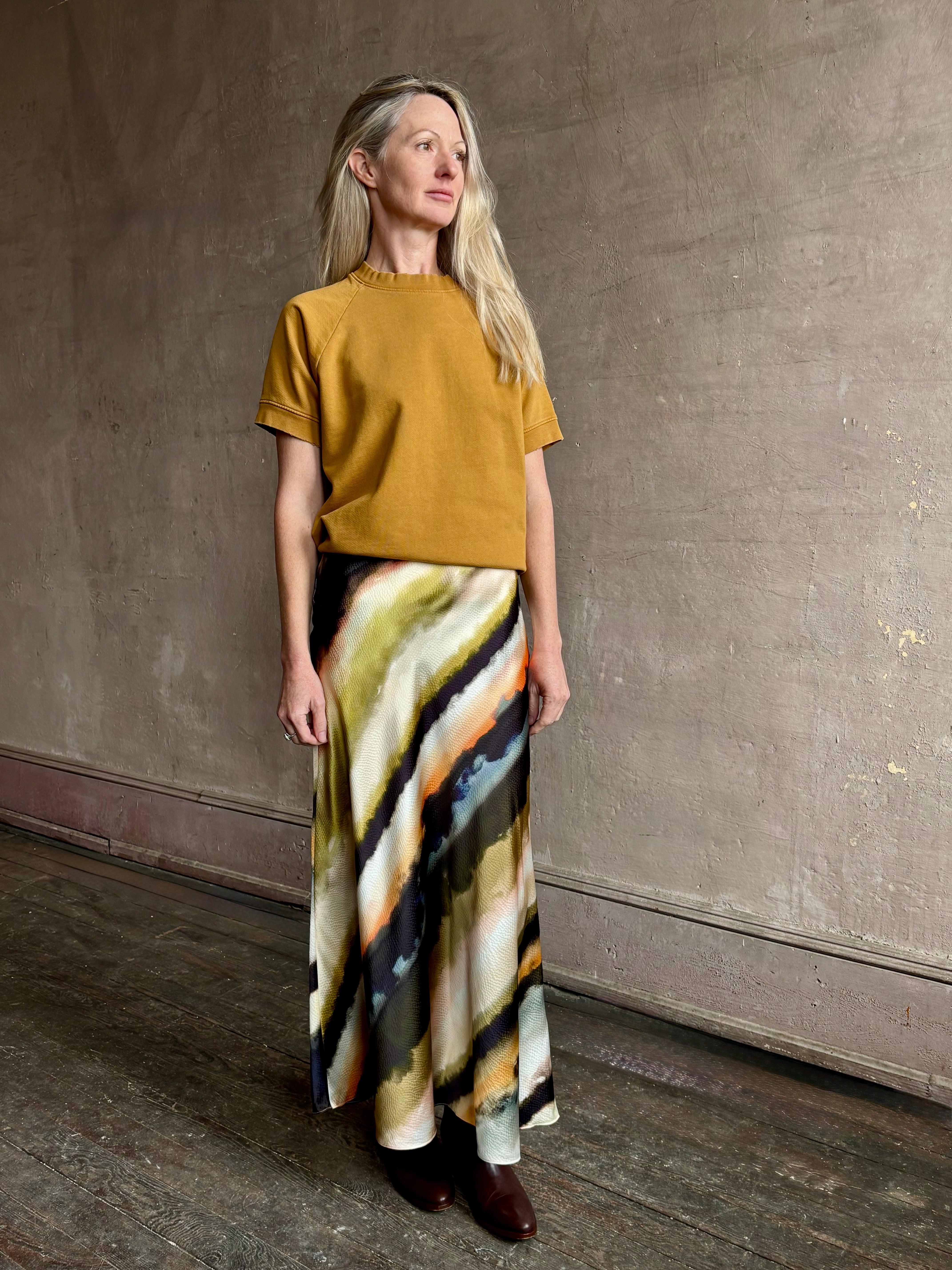 Image of mature woman wearing designer Cara Cara hammered silk maxi slip skirt with abstract multi-color print that can be dressed up or down