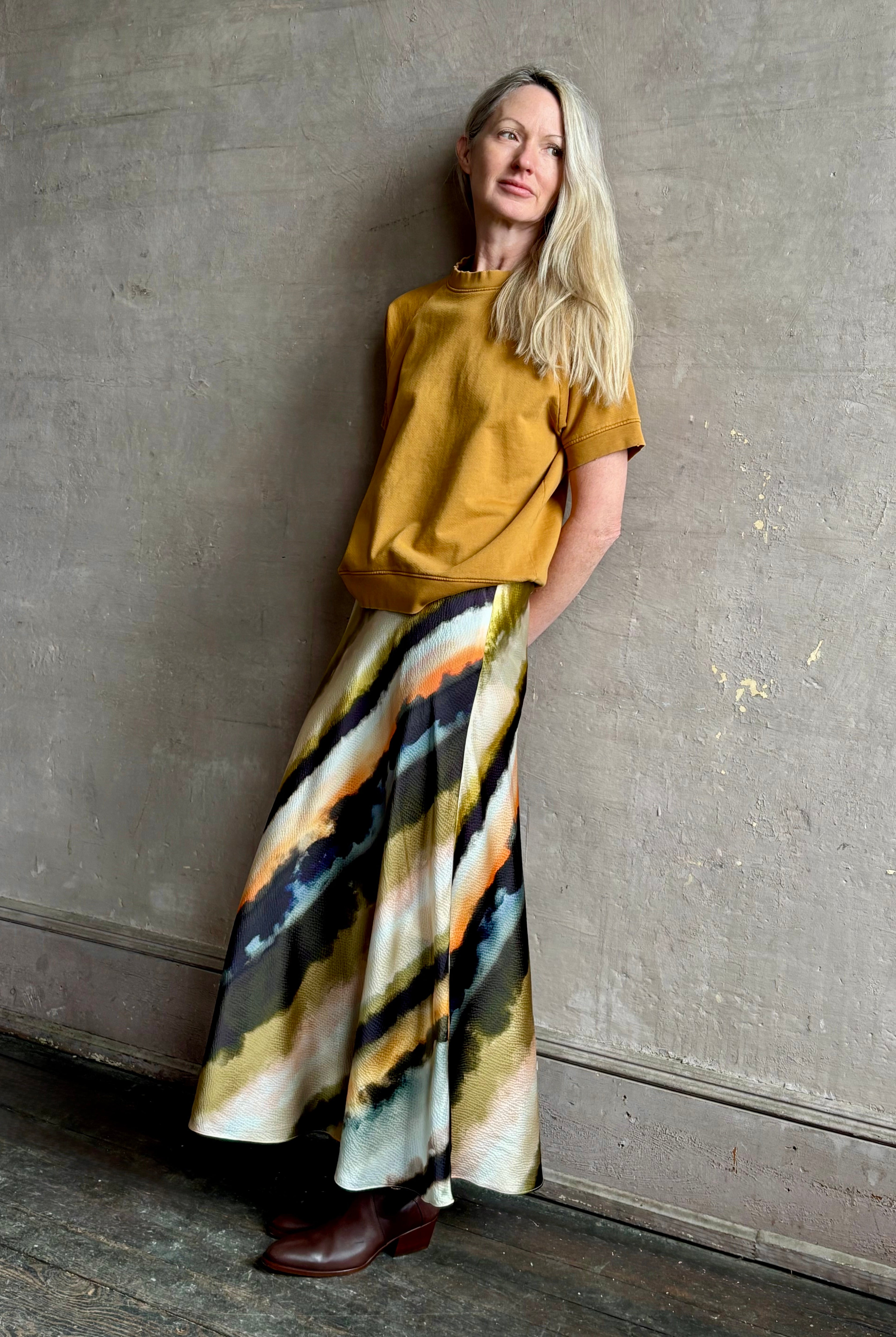 Image of mature woman wearing designer Cara Cara hammered silk maxi slip skirt with abstract multi-color print that can be dressed up or down