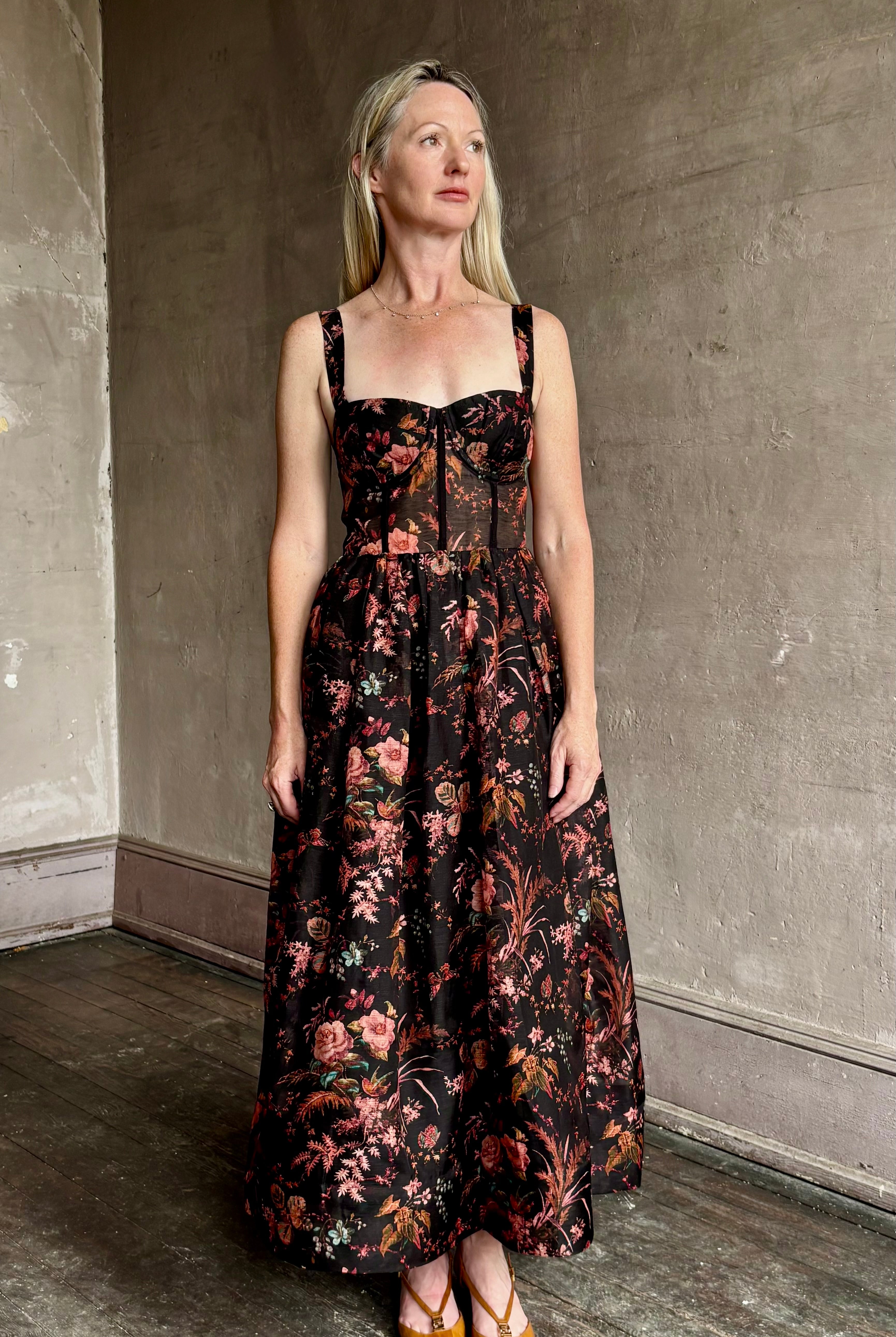 Image of woman wearing premium linen-silk Pheobe midi dress by Cara Cara with expertly crafted unlined corset bodice in an elegant black floral print