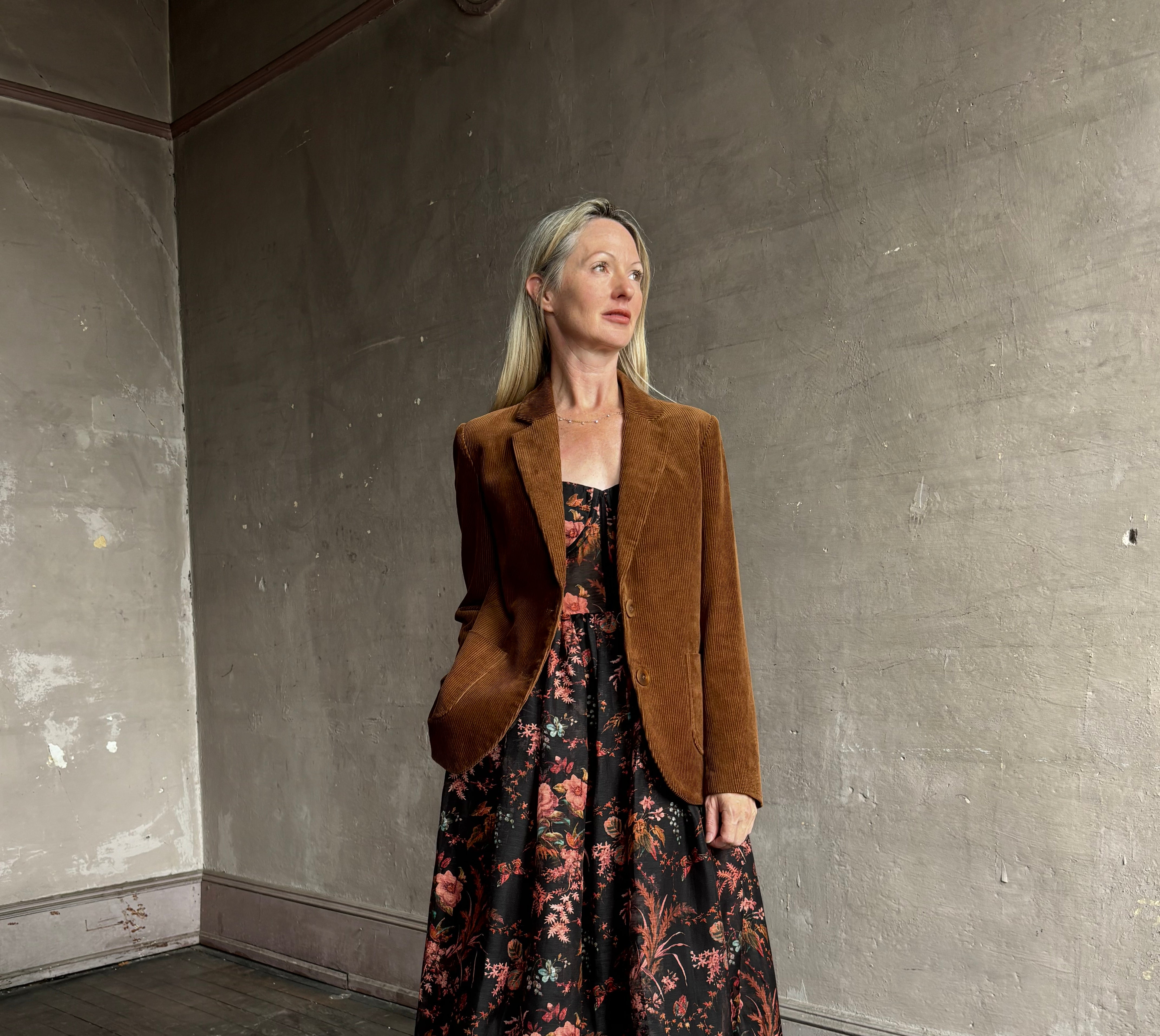Image of woman wearing premium linen-silk Pheobe midi dress by Cara Cara with expertly crafted unlined corset bodice in an elegant black floral print