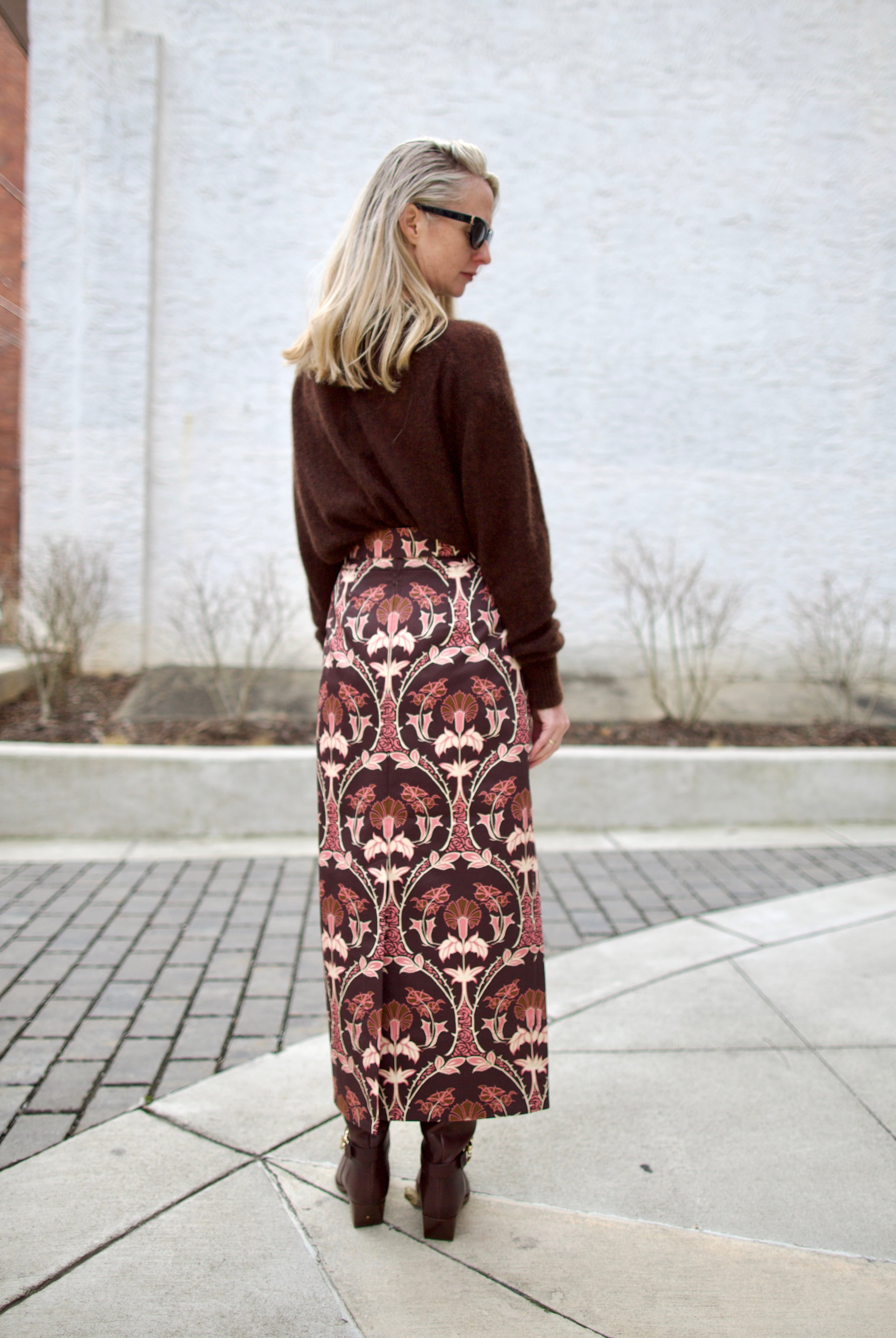 back image of a woman wearing the cara cara arcada skirt, ulla johnson willow boots and apiece apart tissue weight sweater