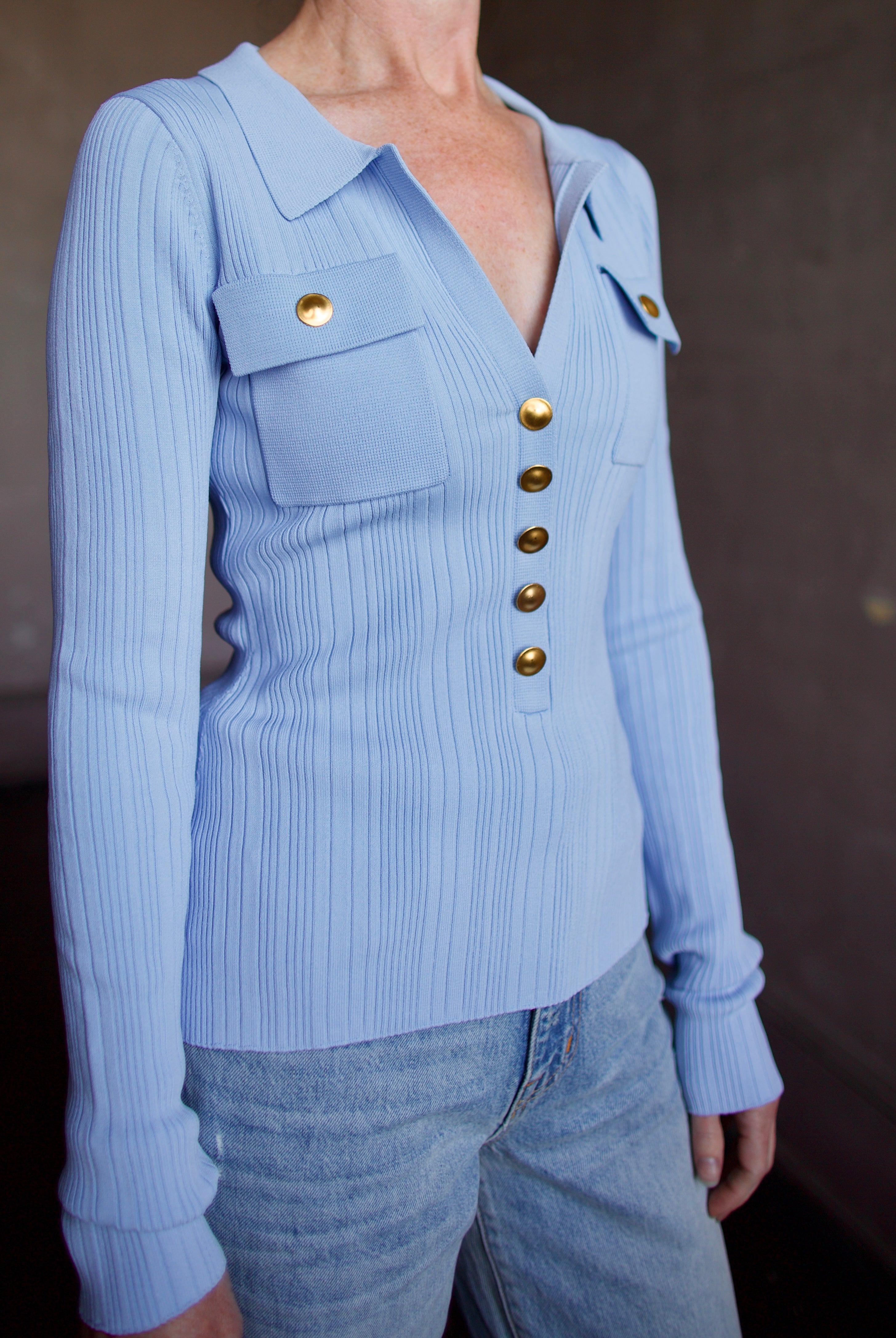 Image of woman wearing Cara Cara Belleport Top in Sky Blue premium viscose-nylon-spandex ribbed texture button front closure, flap pockets, and gold buttons