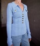 Image of woman wearing Cara Cara Belleport Top in Sky Blue premium viscose-nylon-spandex ribbed texture button front closure, flap pockets, and gold buttons