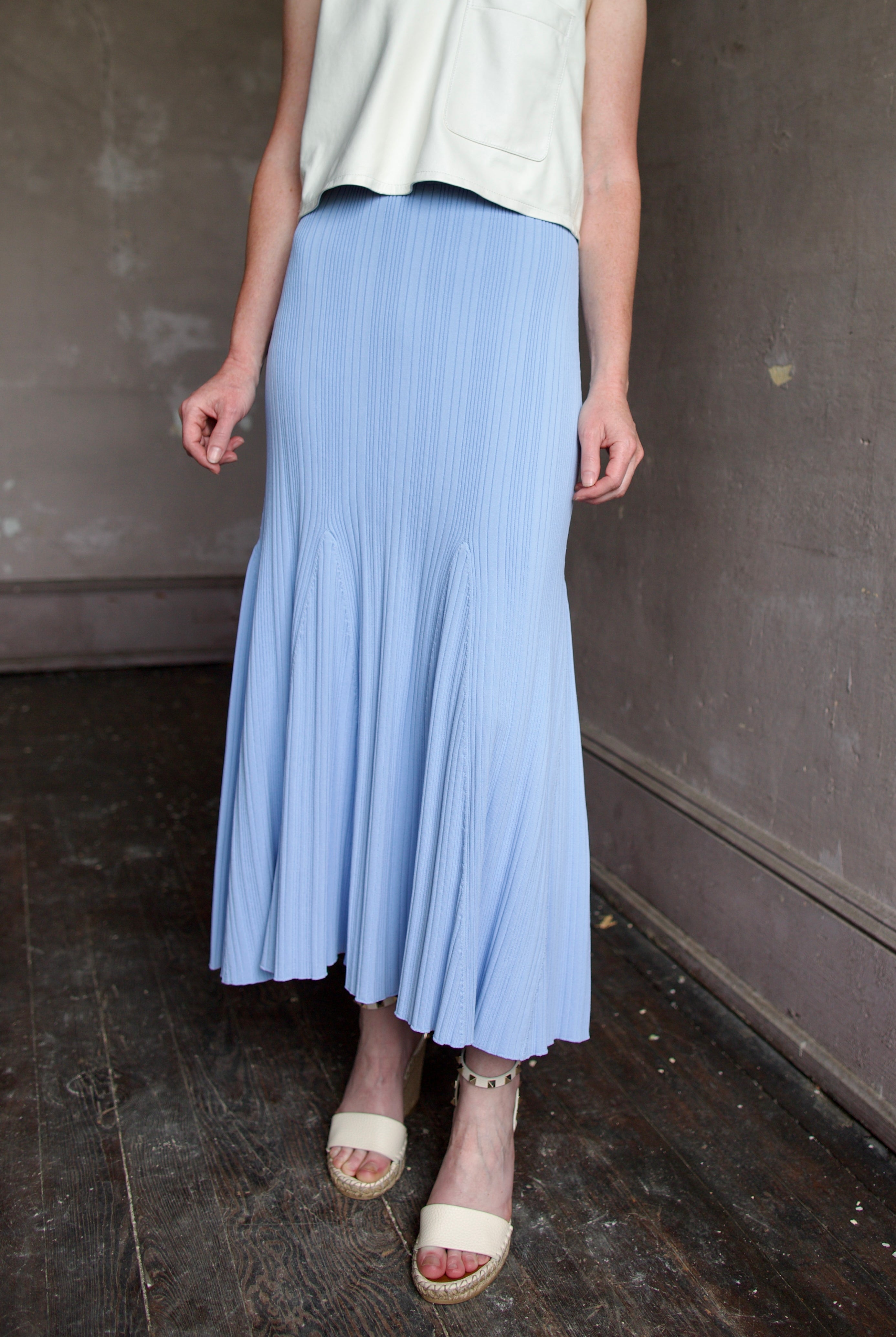 Image of woman wearing Cara Cara Dara Skirt in Sky Blue viscose-nylon-spandex construction with elegant ribbed texture, high-rise waist, and slightly flared hem
