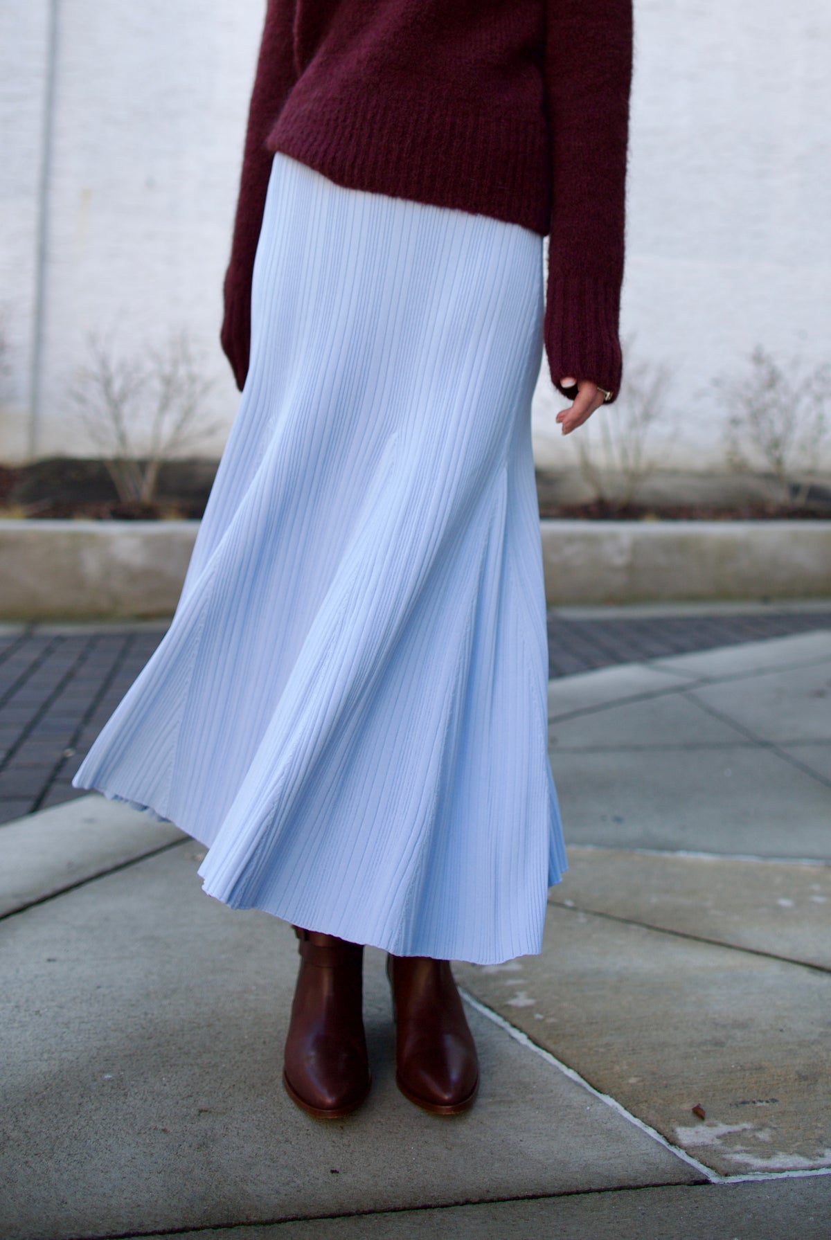 Mature woman wearing Cara Cara Dara Skirt in Sky Blue Knit construction elegant ribbed texture fit and flare sihlouette heavy fall knit weight
