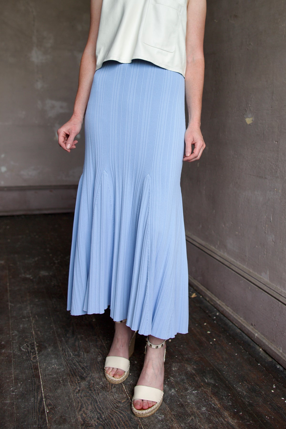Mature woman wearing Cara Cara Dara Skirt in Sky Blue viscose-nylon-spandex construction with elegant ribbed texture, high-rise waist, and slightly flared hem