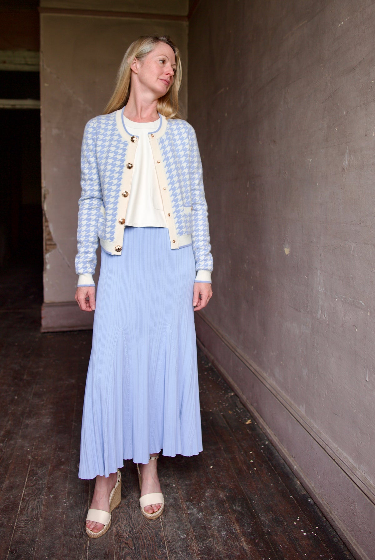 Mature woman wearing the Cara Cara Priscilla Cardigan and Dara Skirt in Sky Blue for luxury layering style guide
