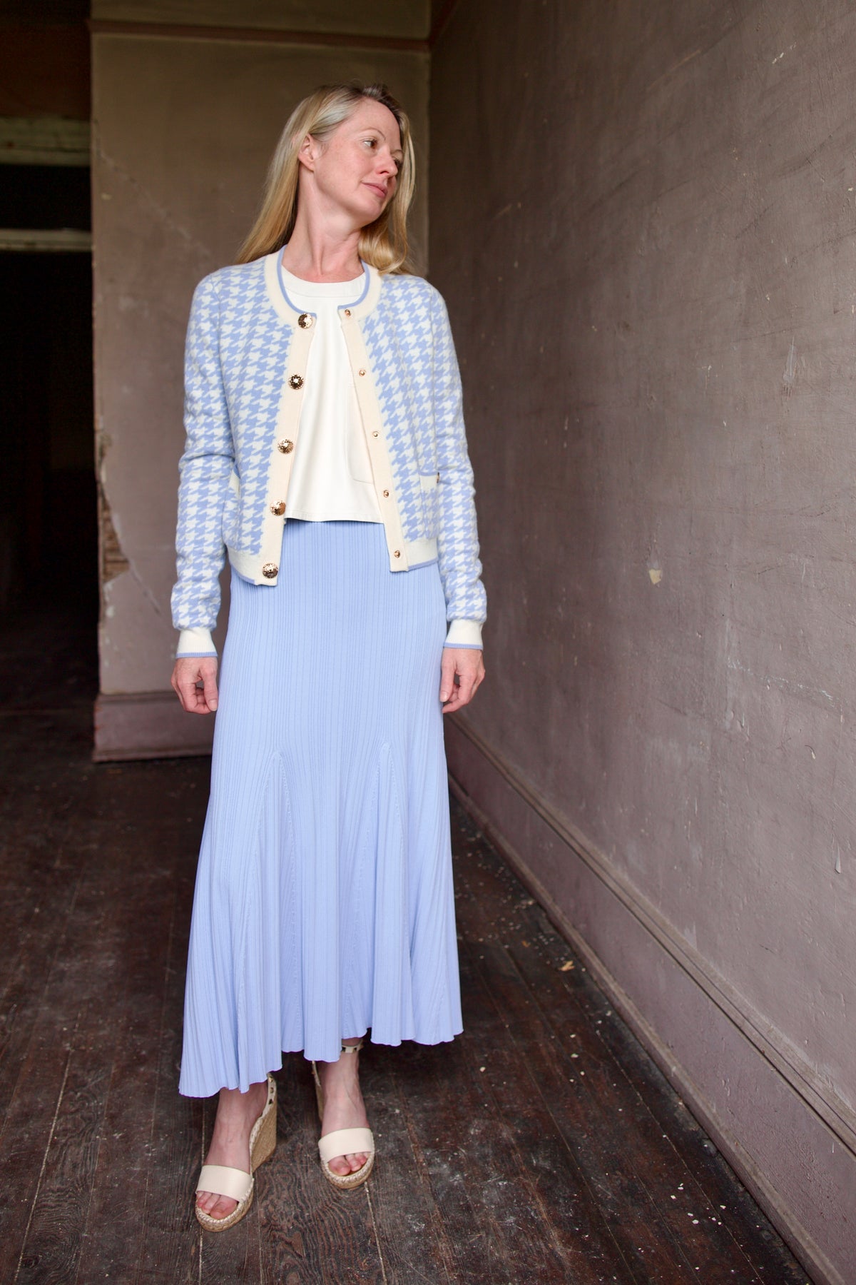 Mature woman wearing the Cara Cara Priscilla Cardigan and Dara Skirt in Sky Blue for luxury layering style guide