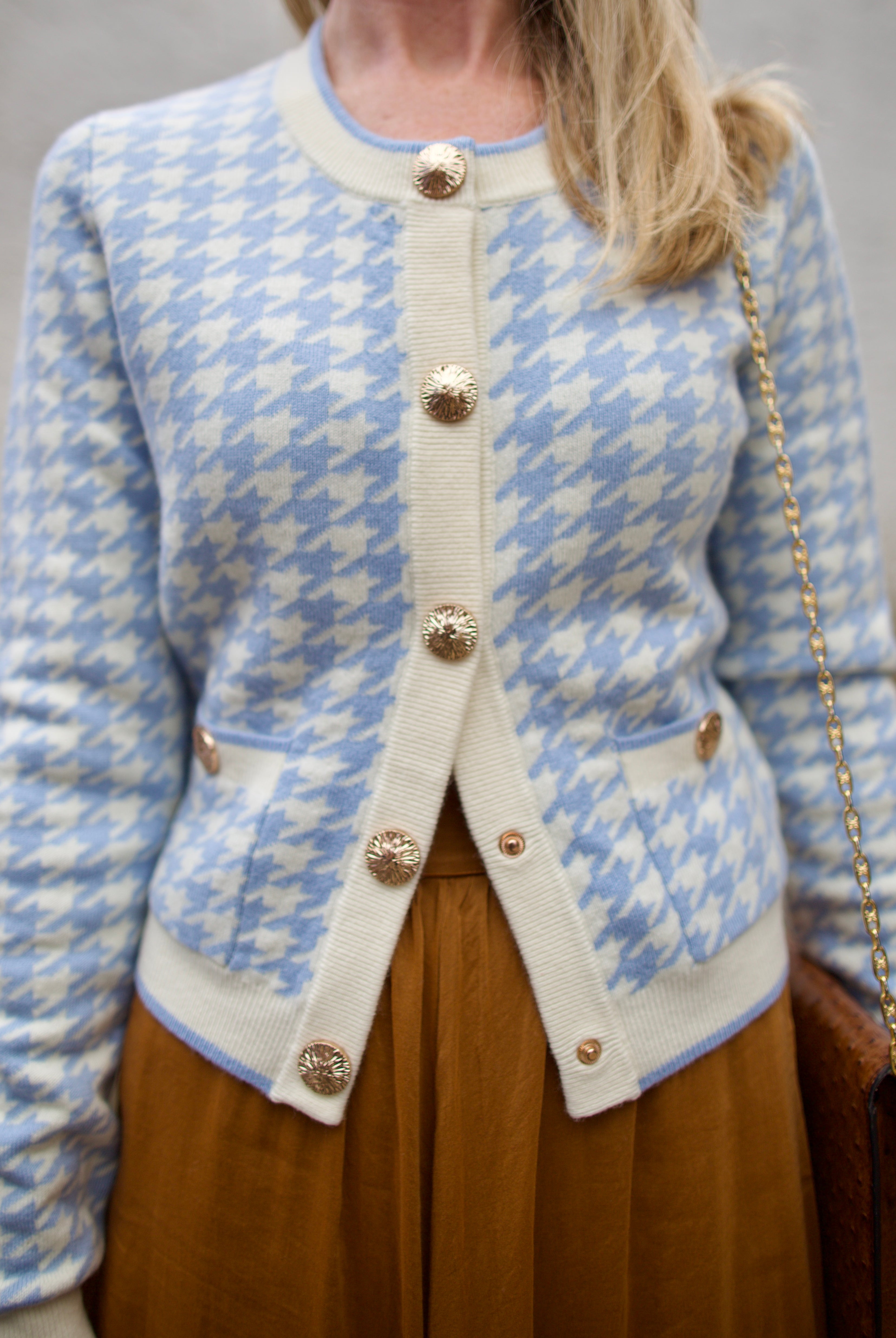 close up image of a woman wearing the Cara Cara priscilla cardigan and forte forte skirt.