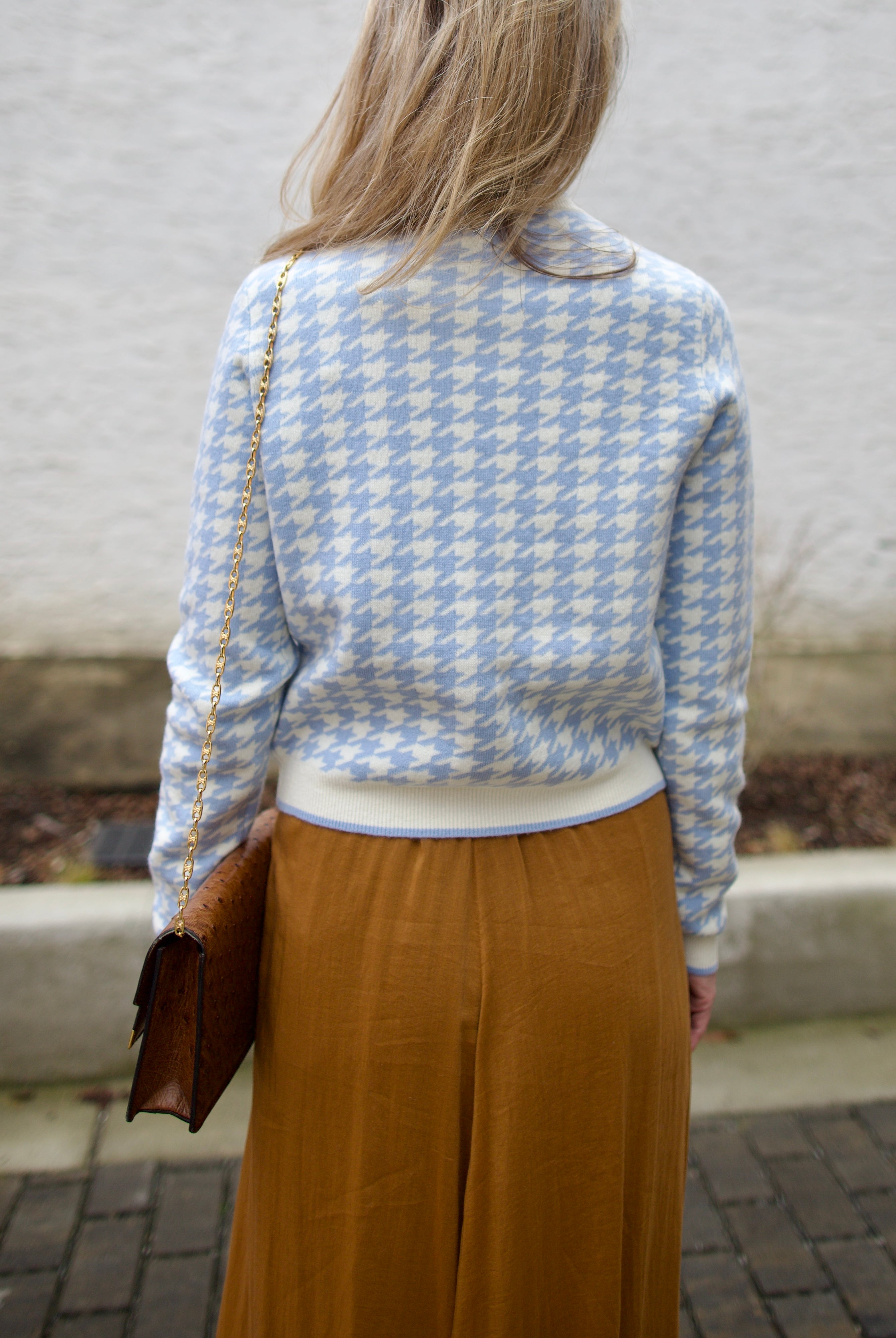 close up image of a woman wearing the Cara Cara priscilla cardigan and forte forte skirt.