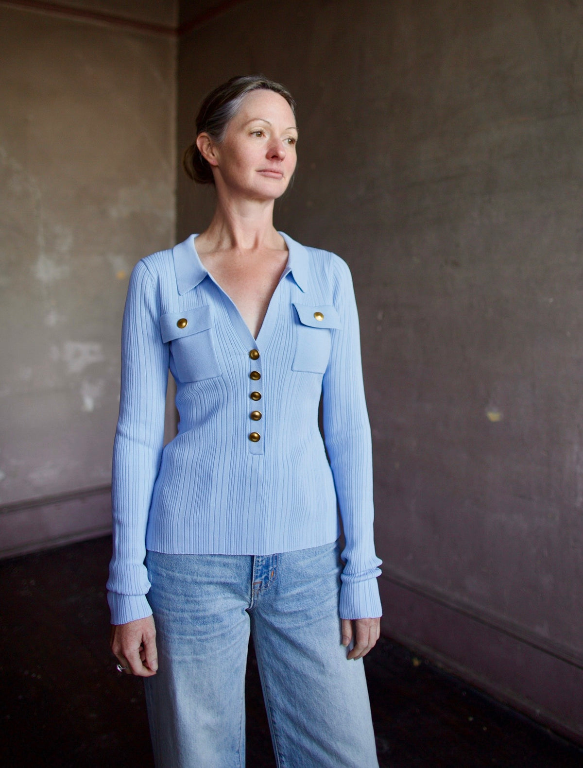 Mature woman wearing Cara Cara Belleport Top in Sky Blue premium viscose-blend ribbed texture button front closure, flap pockets gold buttonslong sleeves