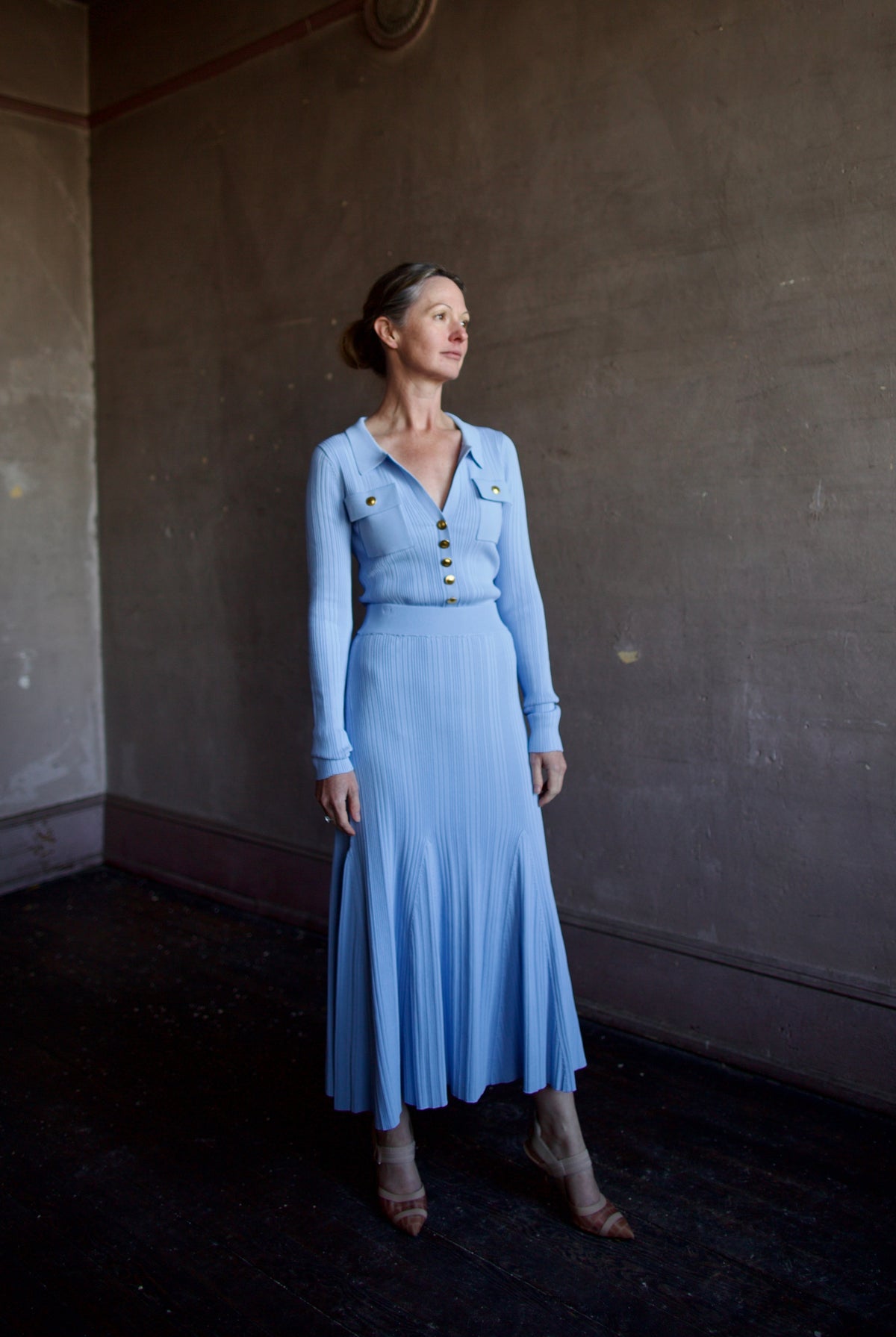 Mature woman wearing Cara Cara Belleport Top in Sky Blue photogaphed with matching knit skirt set