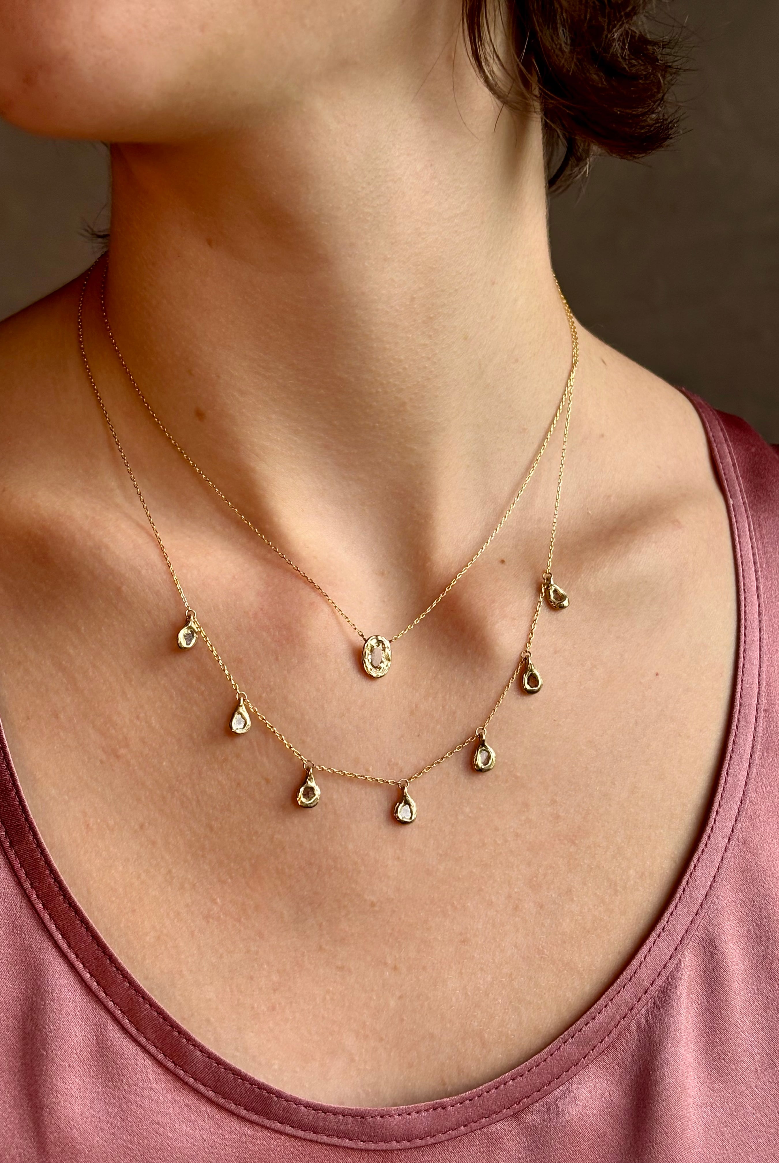 Woman wearing Mirage Cascade Diamond Necklace from New York fine jewelry designer Emilie Shapiro featuring seven dangling rose cut diamonds in 14k yellow gold exquisitely handcrafted in USA