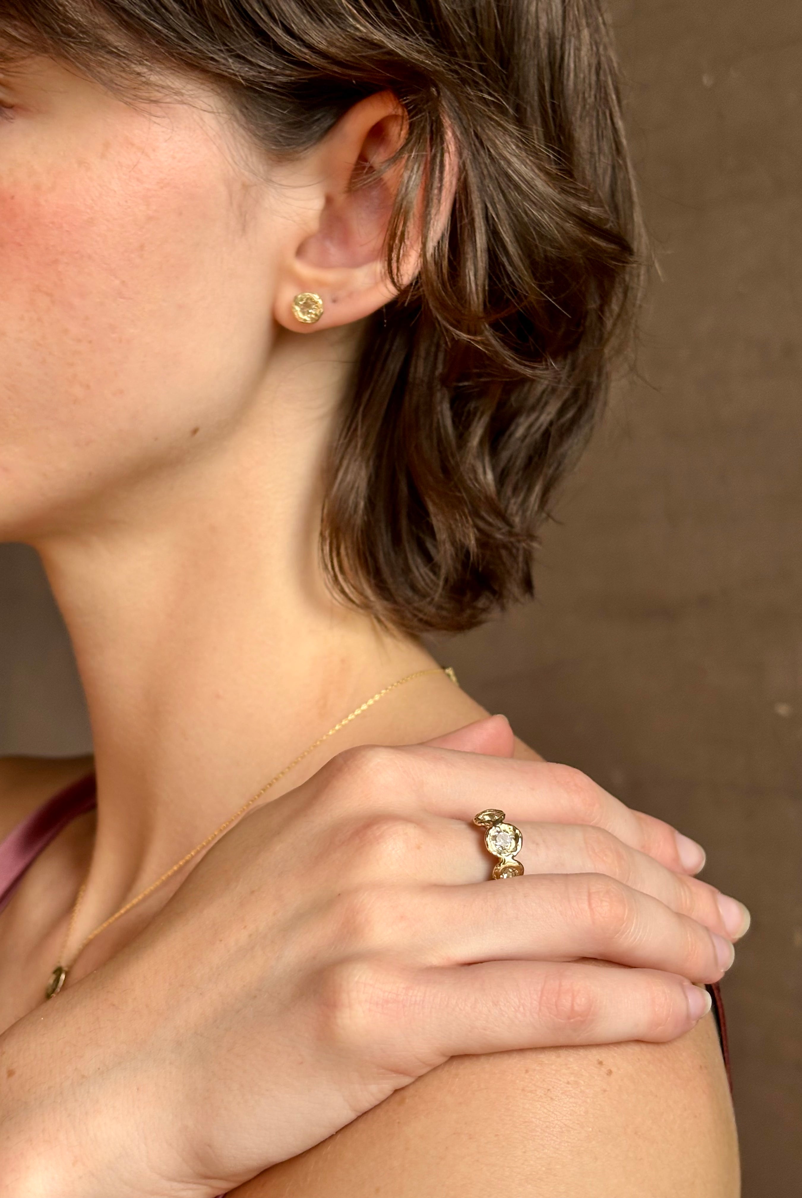 Woman wearing a White Sapphire statement Ring from contemporary fine jewelry designer Emilie Shapiro composed of three round white sapphires set in 14k yellow gold handcrafted in USA
