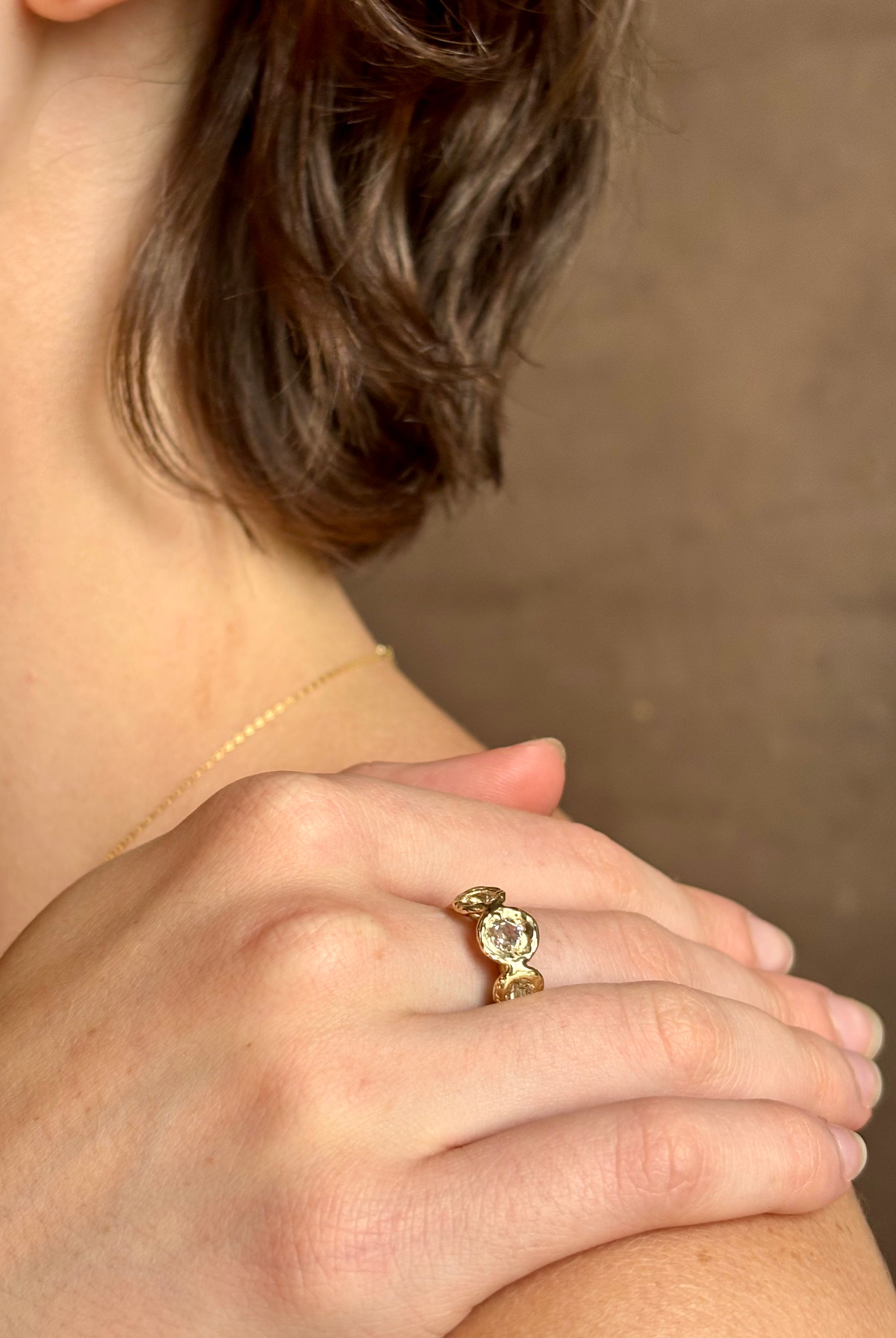 Woman wearing a White Sapphire statement Ring from contemporary fine jewelry designer Emilie Shapiro composed of three round white sapphires set in 14k yellow gold handcrafted in USA