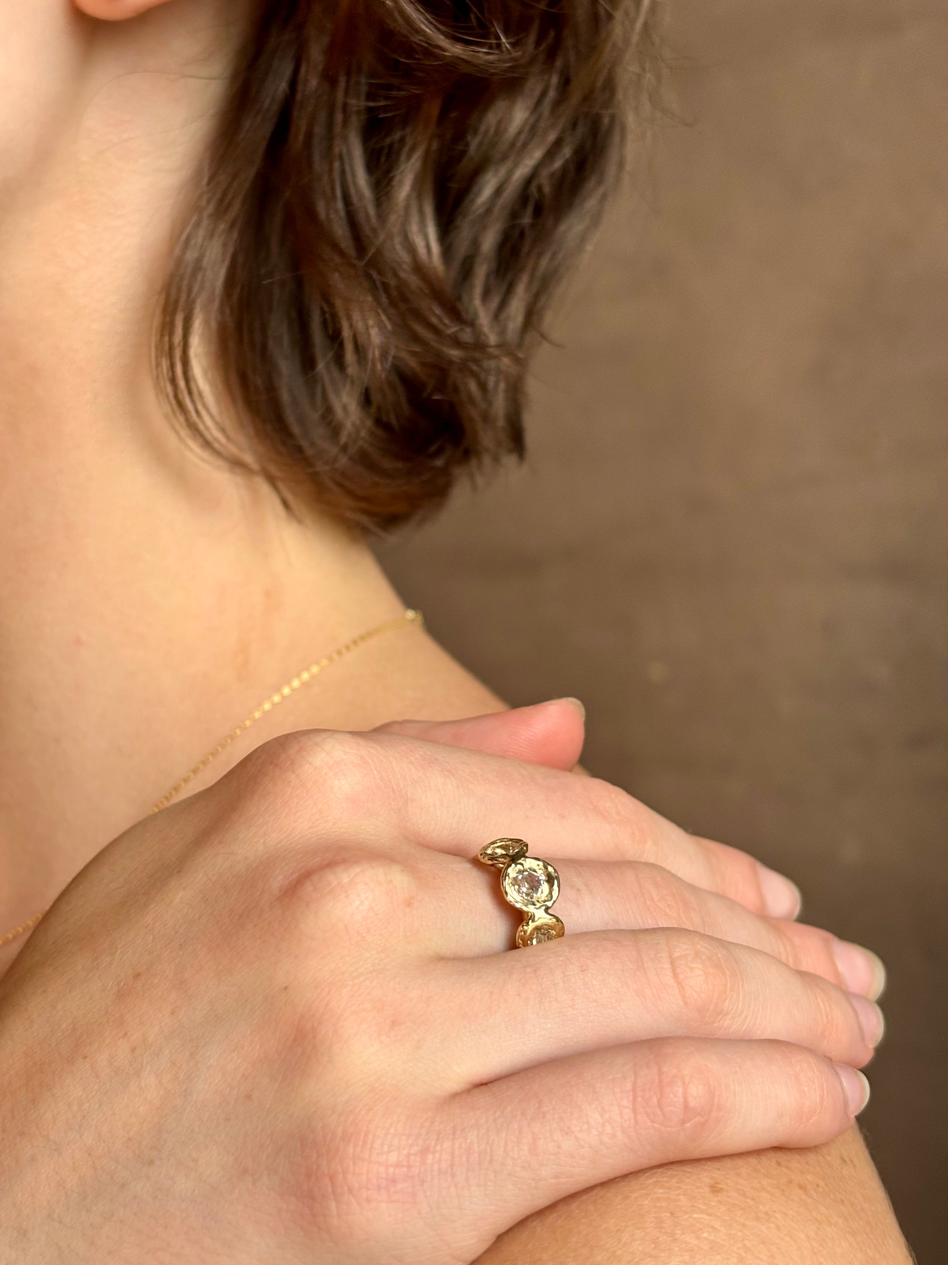 Woman wearing a White Sapphire statement Ring from contemporary fine jewelry designer Emilie Shapiro composed of three round white sapphires set in 14k yellow gold handcrafted in USA
