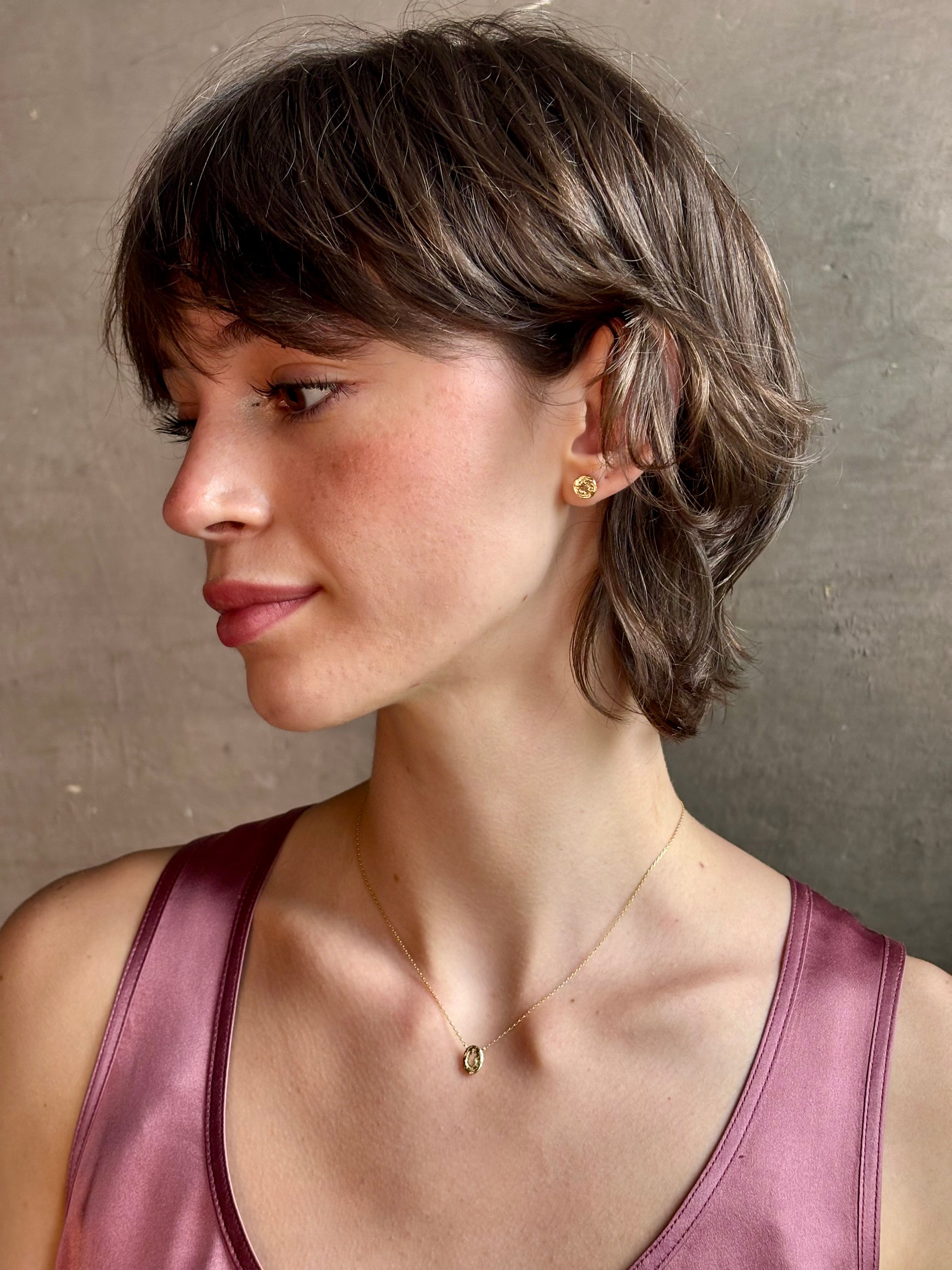 Woman wearing white Sapphire stud earrings from contemporary fine jewelry designer Emilie Shapiro composed of a single round white sapphires set in 14k yellow gold handcrafted in USA