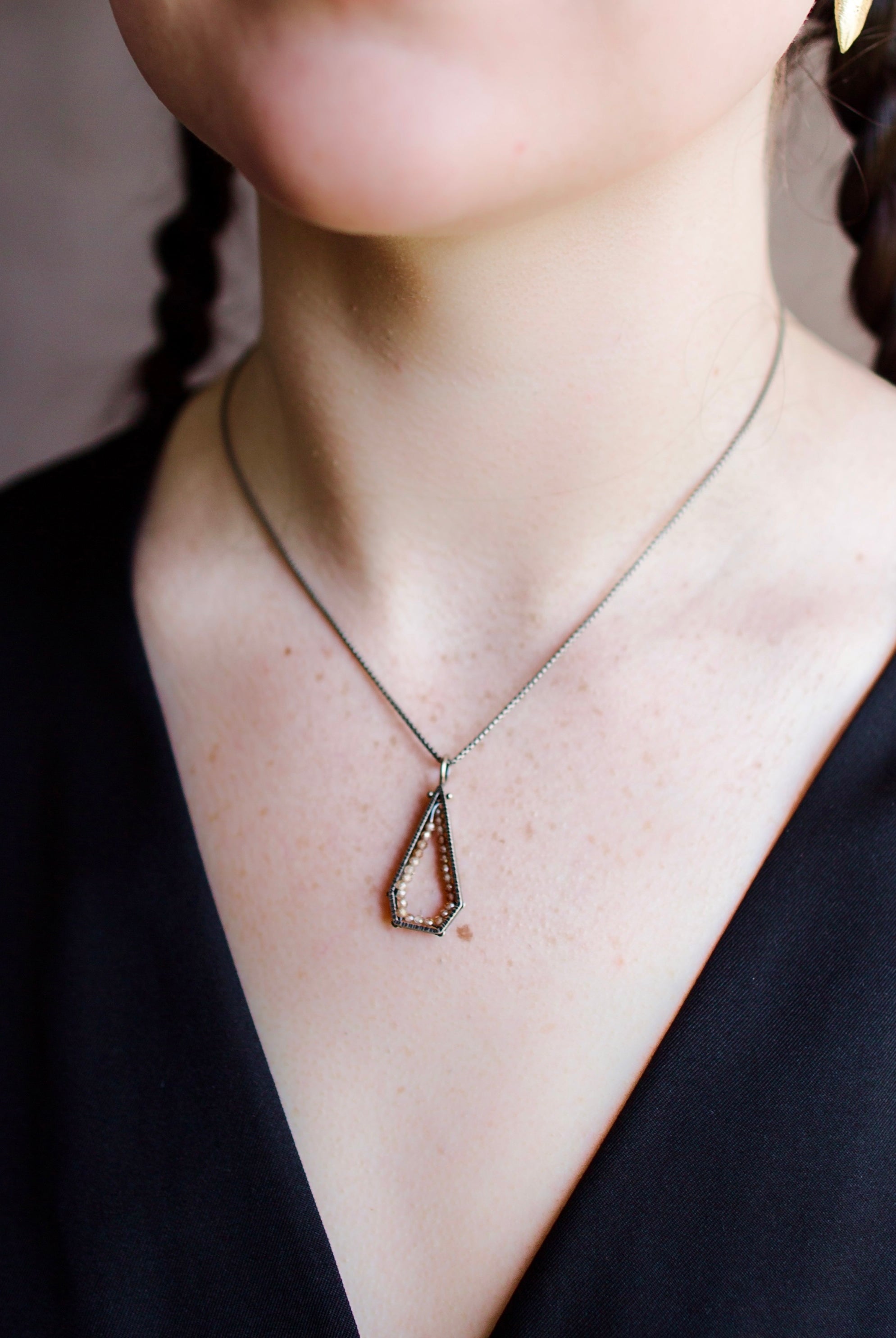 Woman wearing a sterling silver and champagne zircon geometric hexagon pendant necklace by North Carolina jewelry artist Erica Bailey handmade in USA