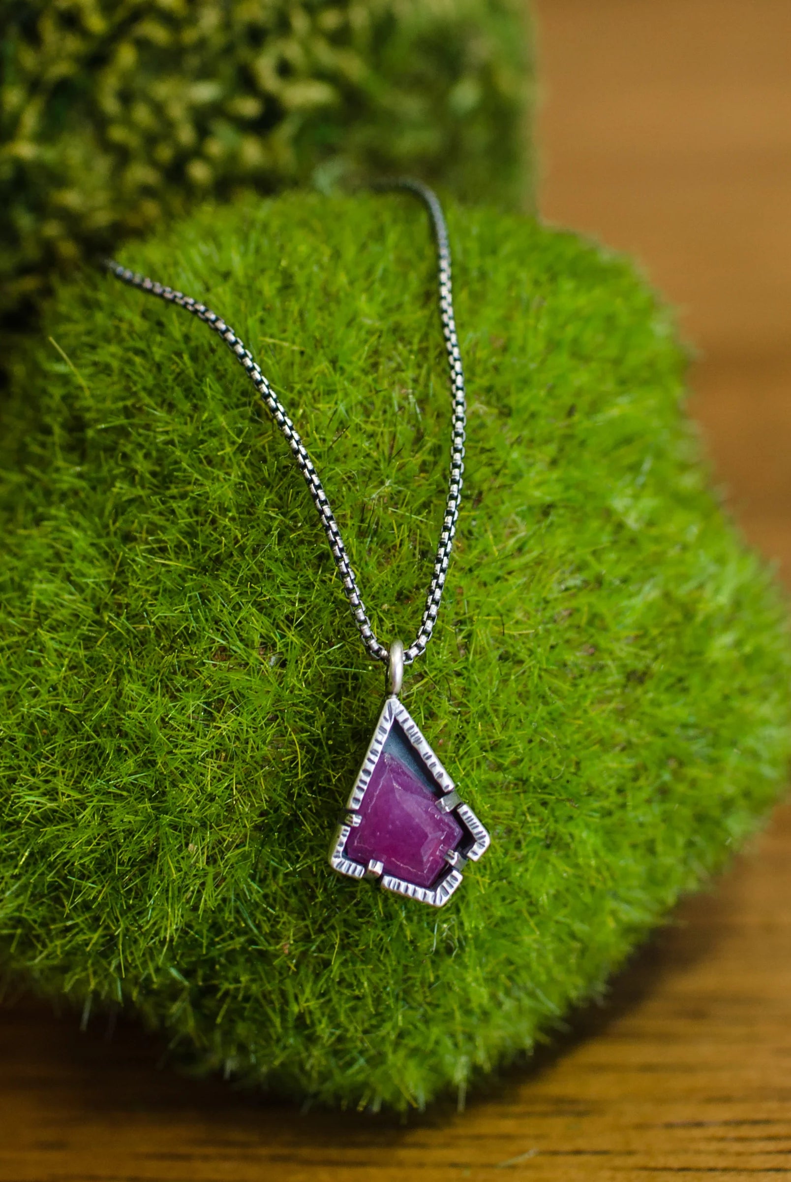 A sterling silver necklace with a red ruby pendant on an 18-inch chain, handmade in USA by Asheville artist Erica Bailey