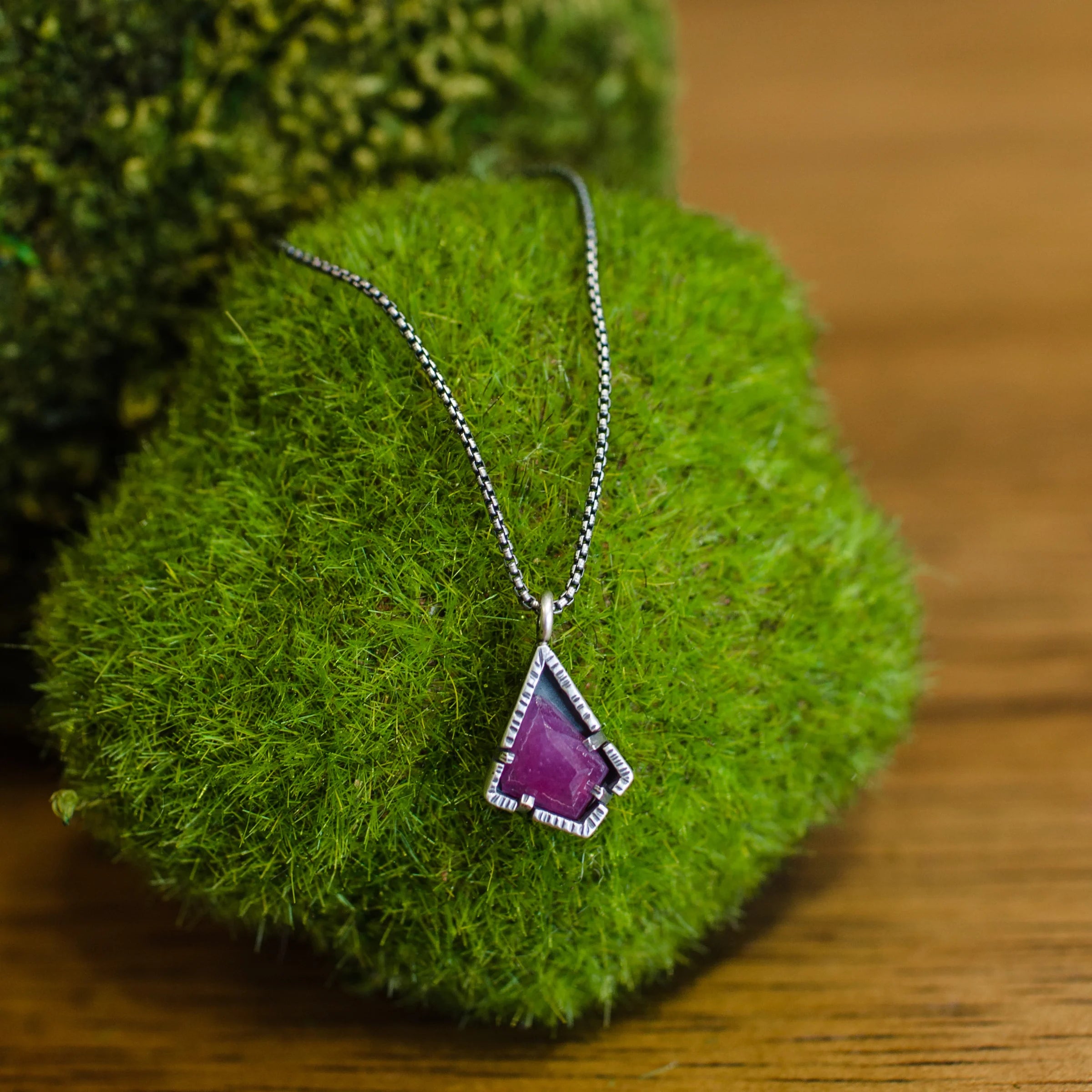 A sterling silver necklace with a red ruby pendant on an 18-inch chain, handmade in USA by Asheville artist Erica Bailey