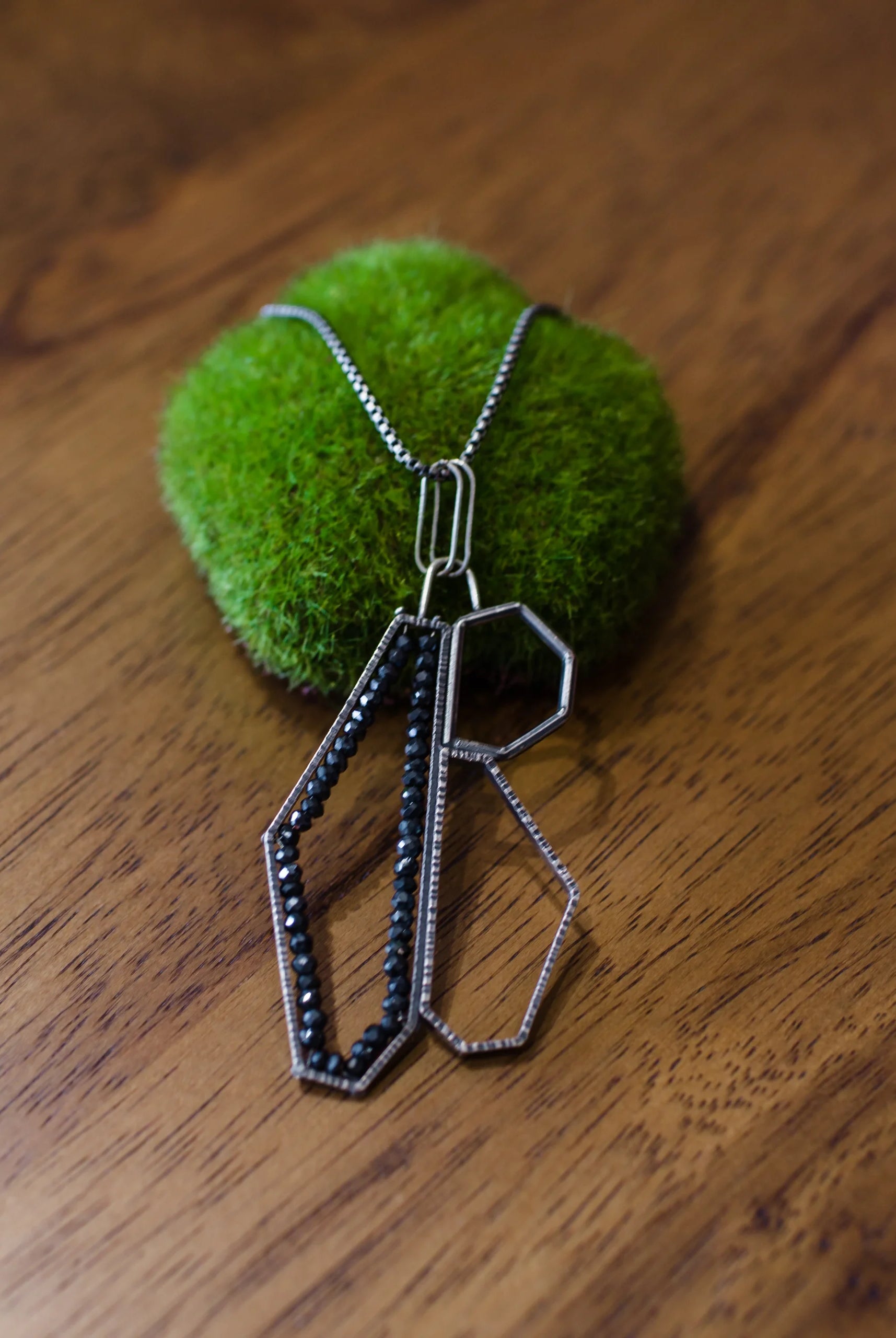 Image showcasing a sterling silver and spinel pendant necklace with a geometric design by North Carolina jewelry artist Erica Bailey